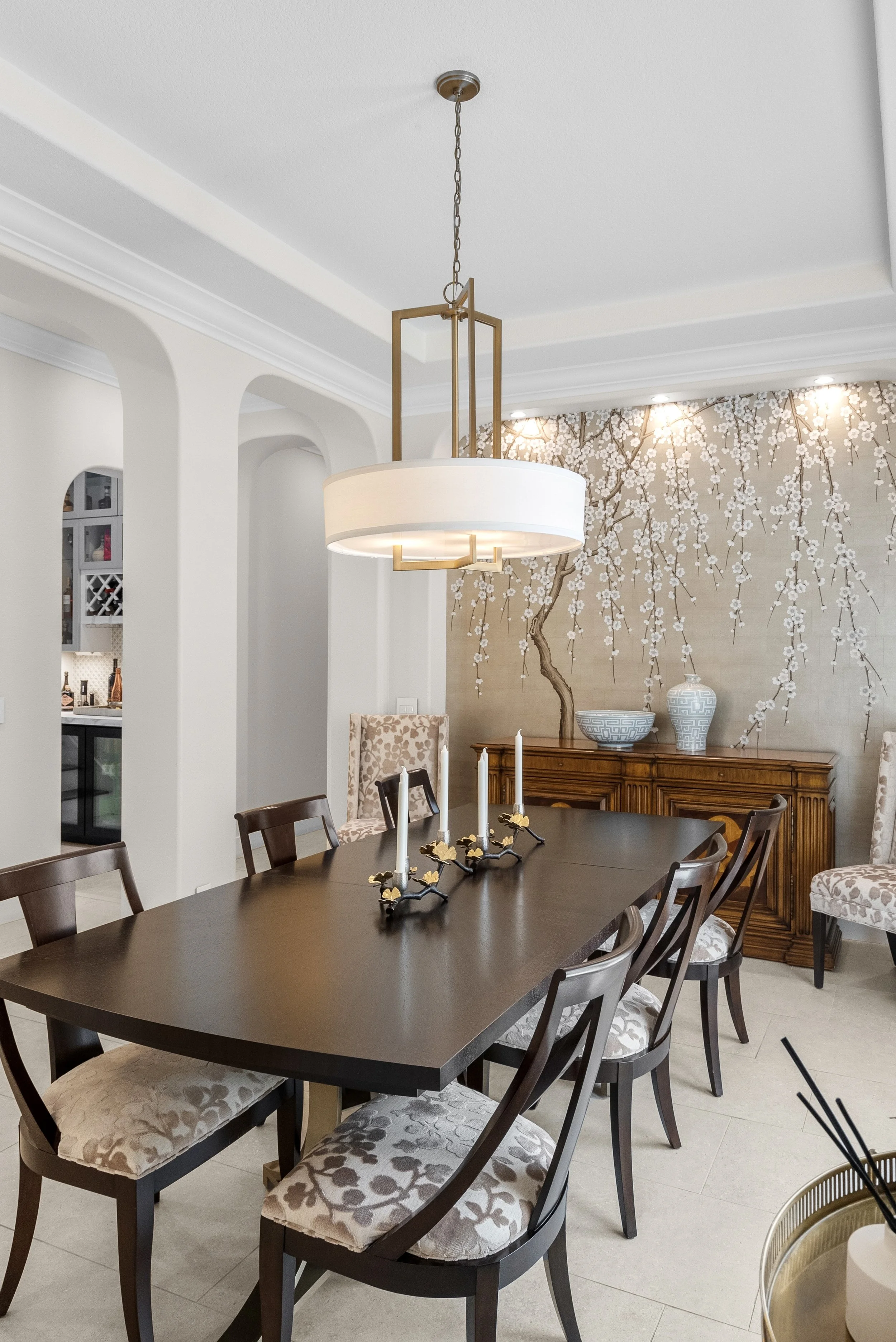 Traditional dining room with a dark wood table, upholstered chairs, and a drum chandelier by Gin Treadwell Interiors in Santa Clarita.