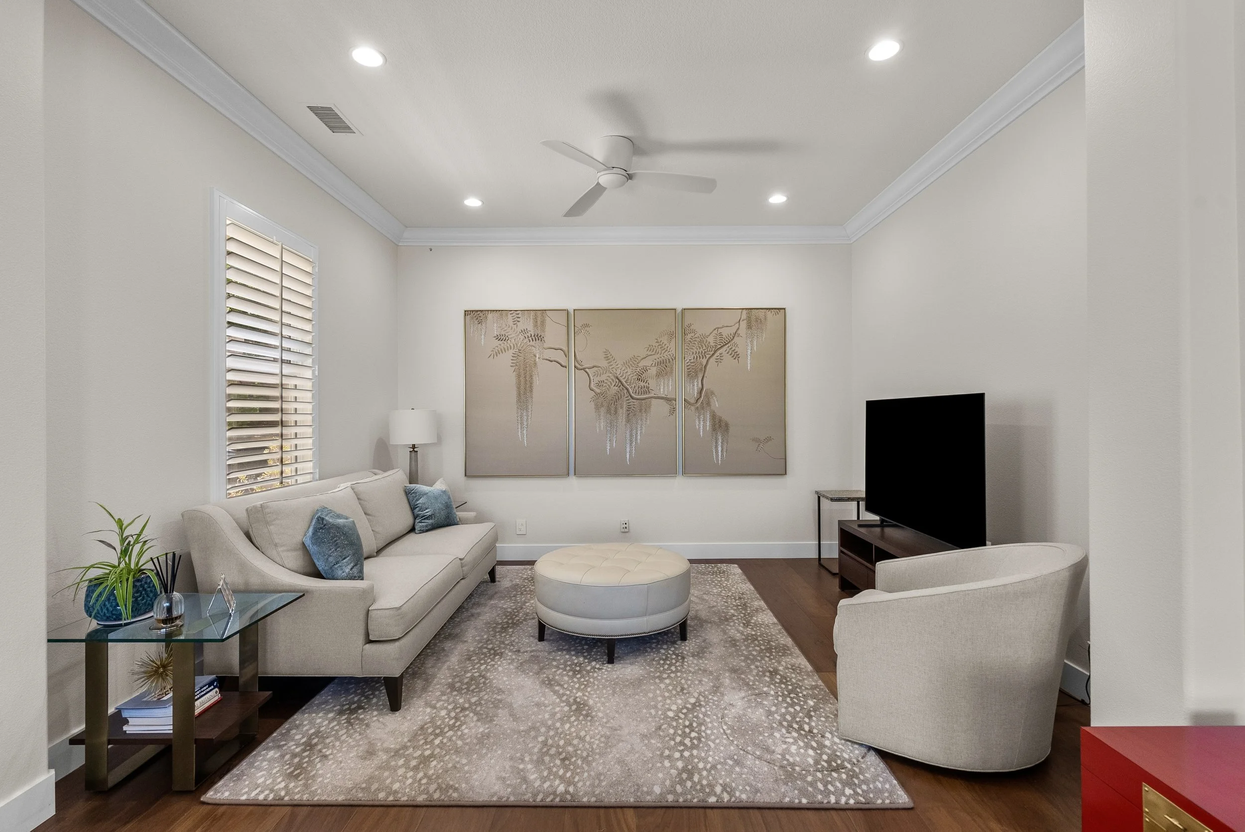 Traditional living room with neutral swivel chairs, layered seating, and framed artwork by Gin Treadwell Interiors in Santa Clarita.