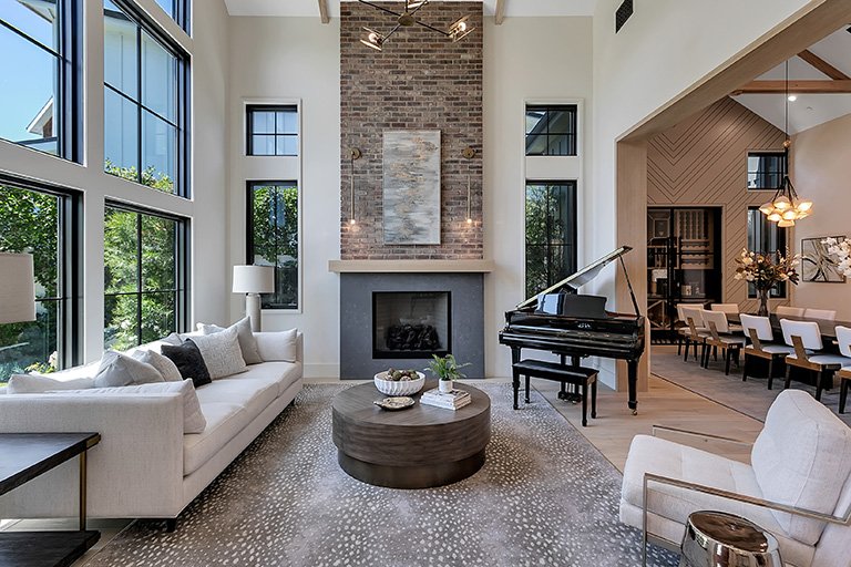 Organic modern living room with a grand piano, layered neutrals, and warm wood accents by Gin Treadwell Interiors in Santa Clarita.