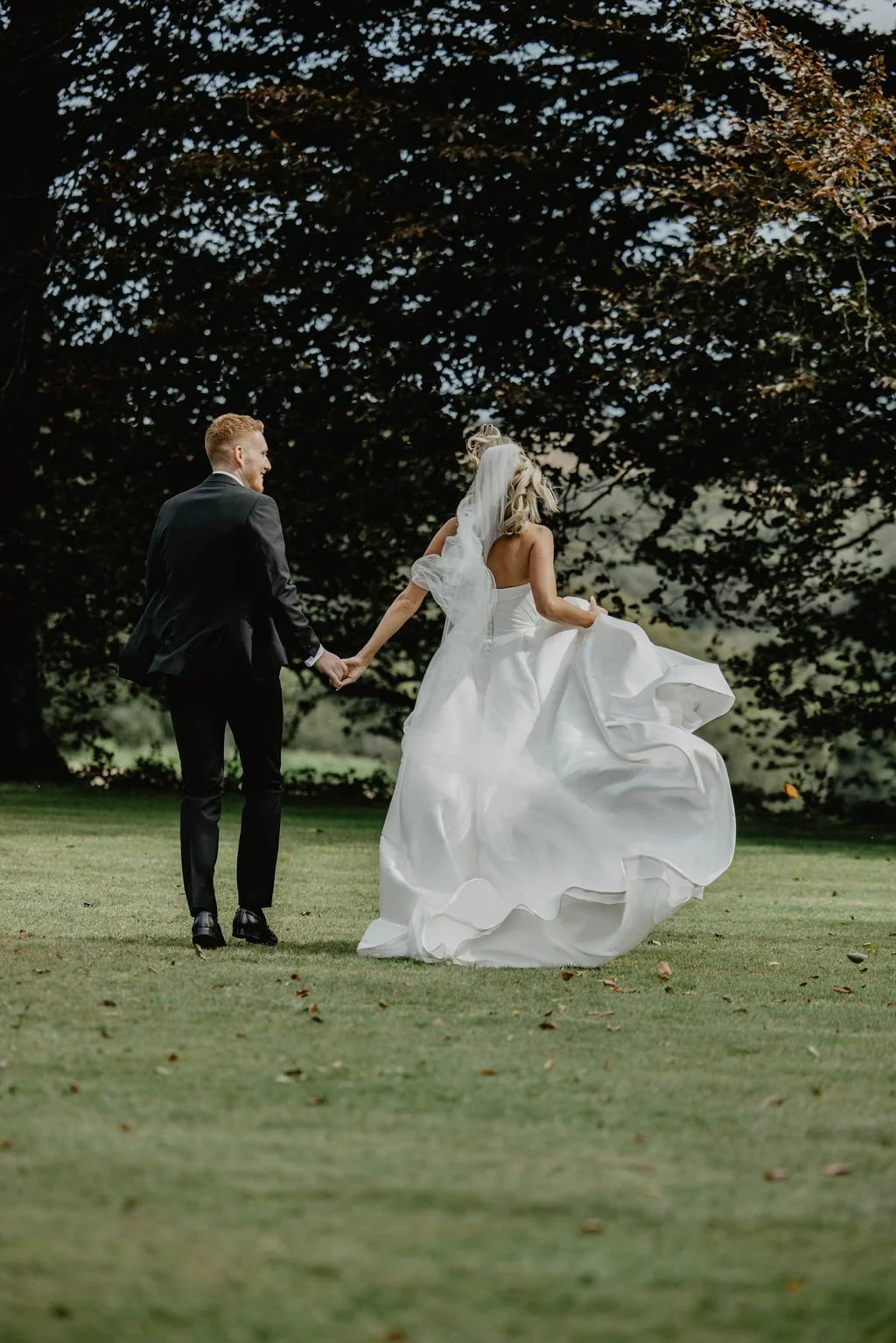 bride and groom running through exclusive-marquee wedding venue in Cornwall