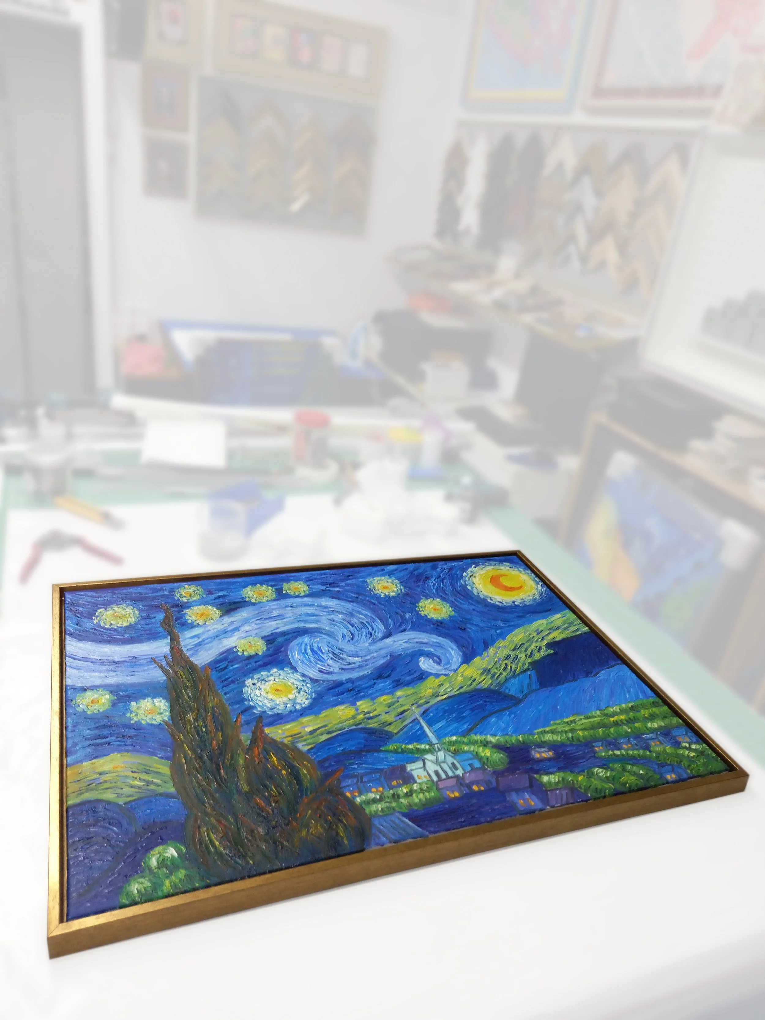 Colorful painting inspired by Vincent van Gogh's "Starry Night" with swirling skies, a church steeple, and rolling hills, framed in wood.