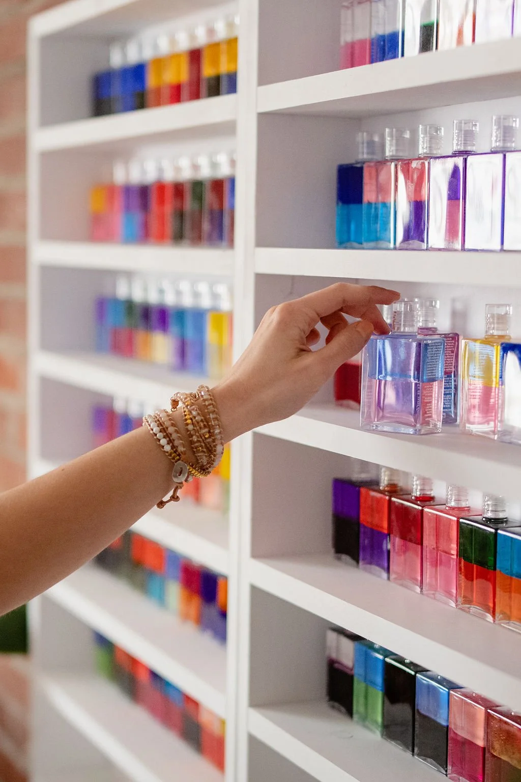 Hand reaching toward colored bottles