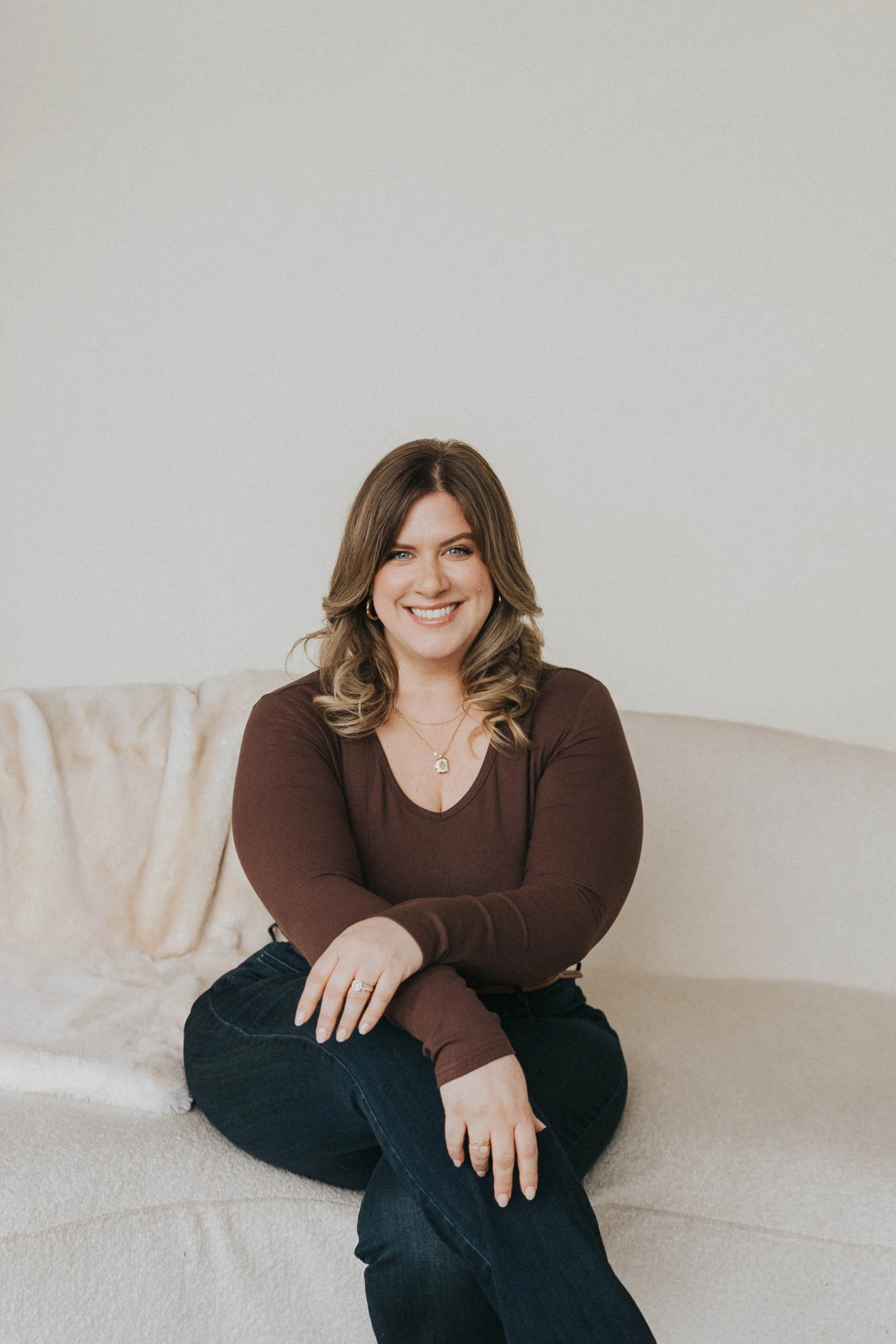 Erica smiling wearing a brown shirt