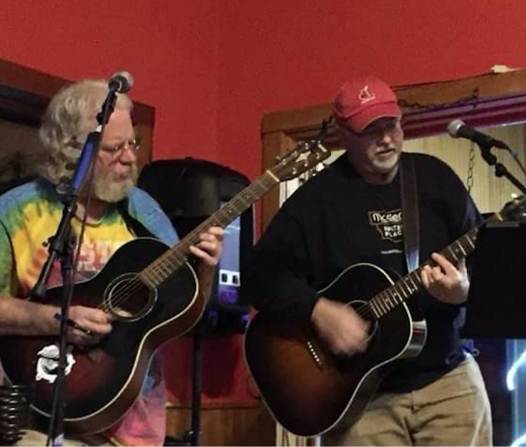 Two hippy dudes playing guitars