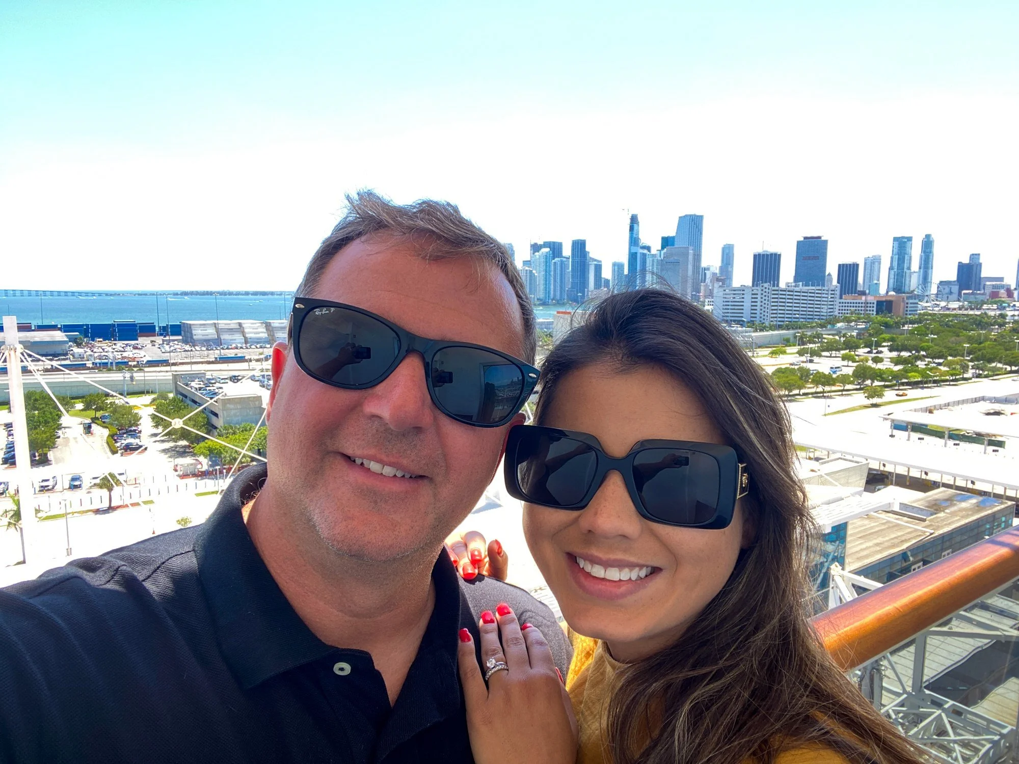 Couple on a Carnival Horizon balcony with the Miami skyline behind them