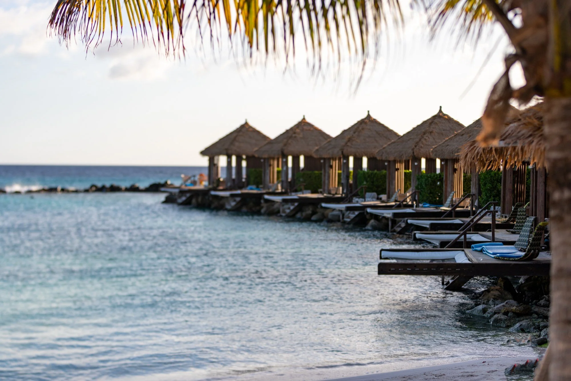 Overwater palapas lining the turquoise water at Renaissance Island