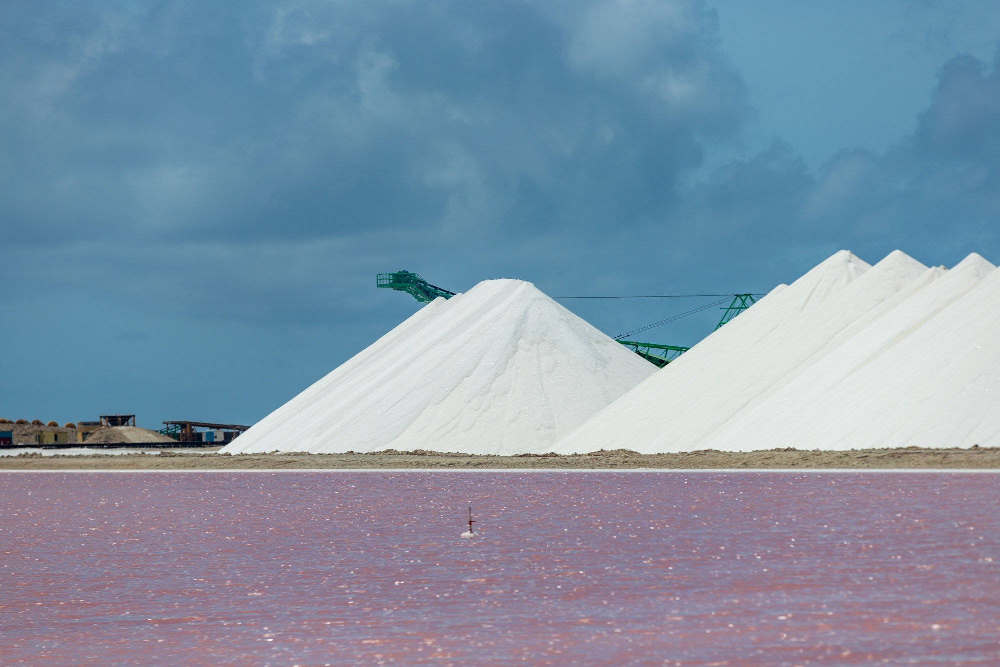 White salt pyramids beside a pink salt pond in Bonaire