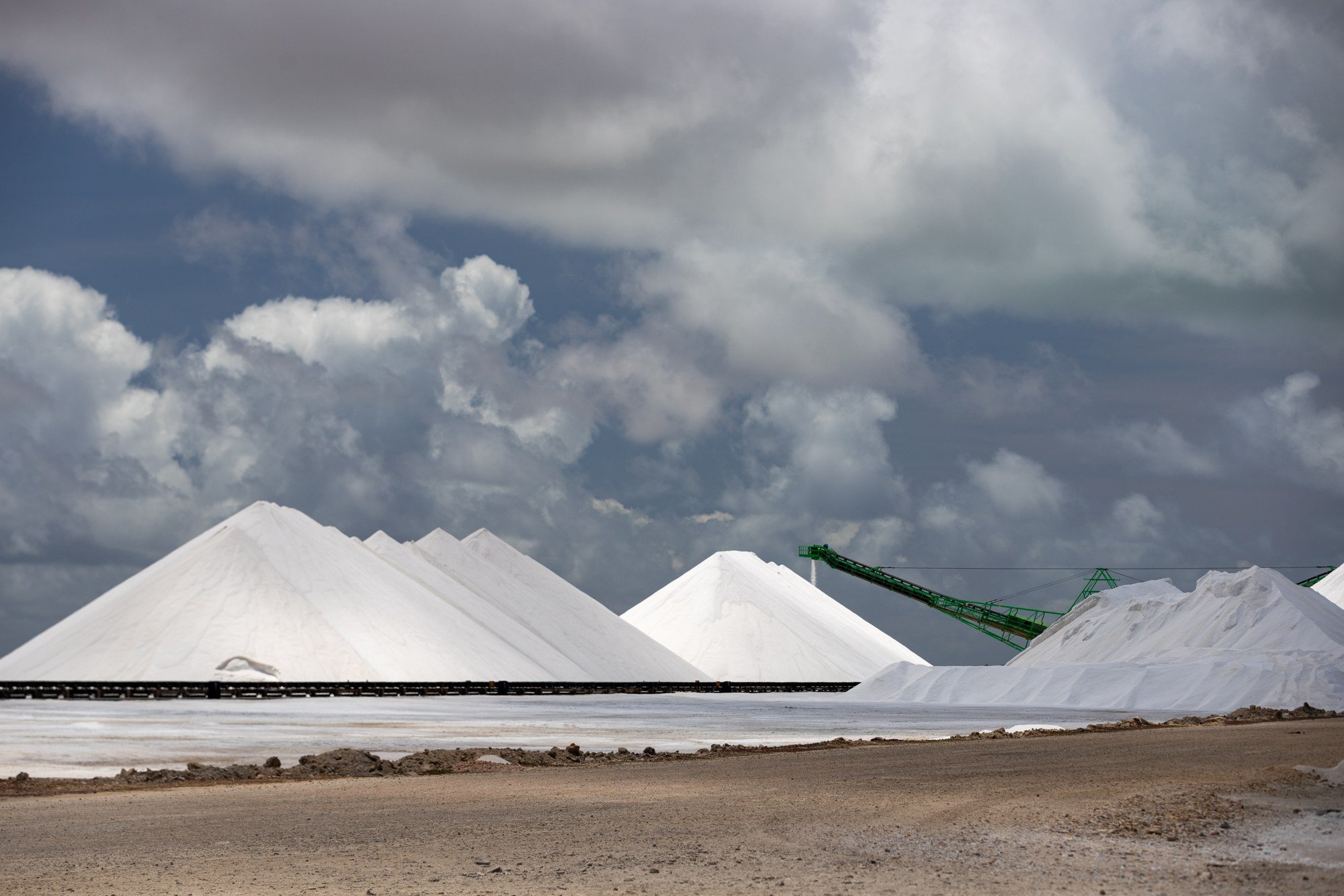 Bonaire salt pyramids beneath dramatic storm clouds