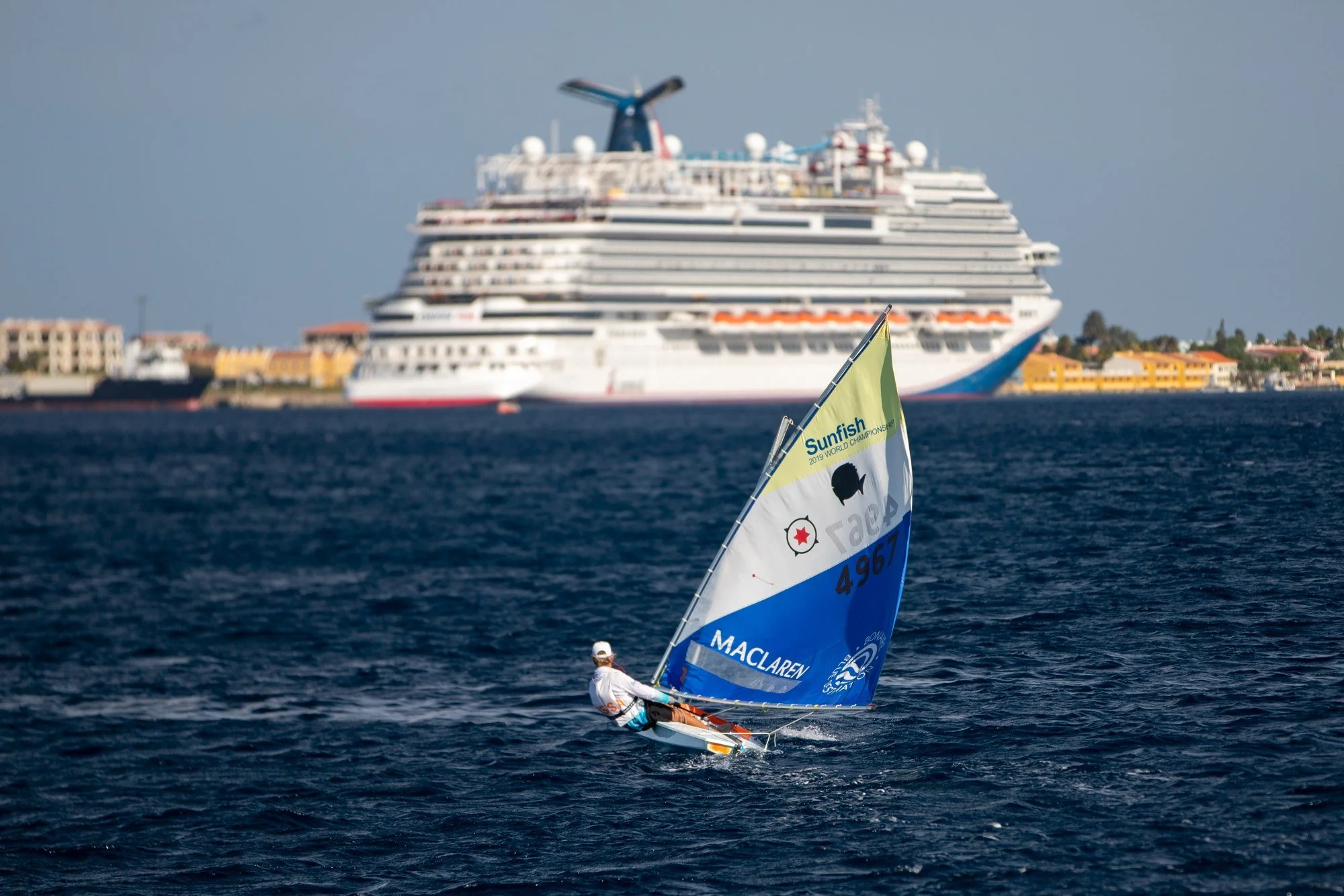 Small sailboat crossing in front of Carnival Horizon in Bonaire