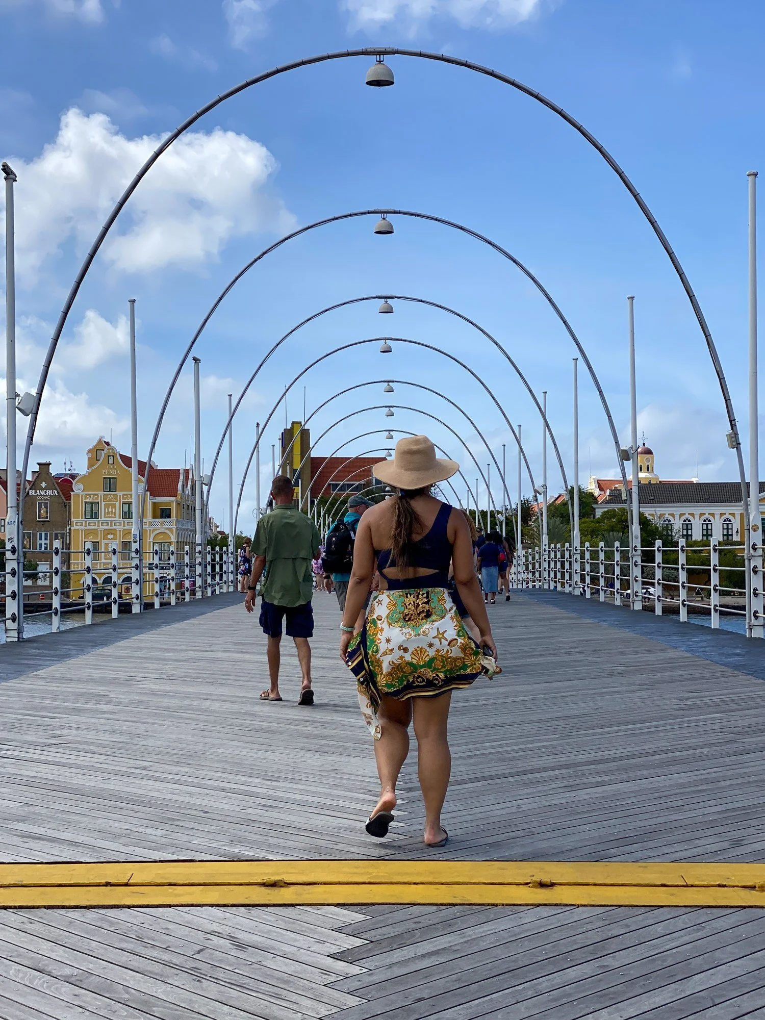 Woman walking across the Queen Emma Bridge in Willemstad