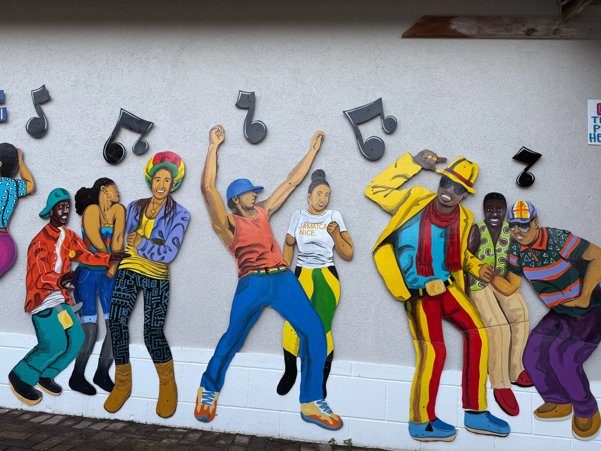 Colorful outdoor mural celebrating Jamaican music, dance, and island culture.
