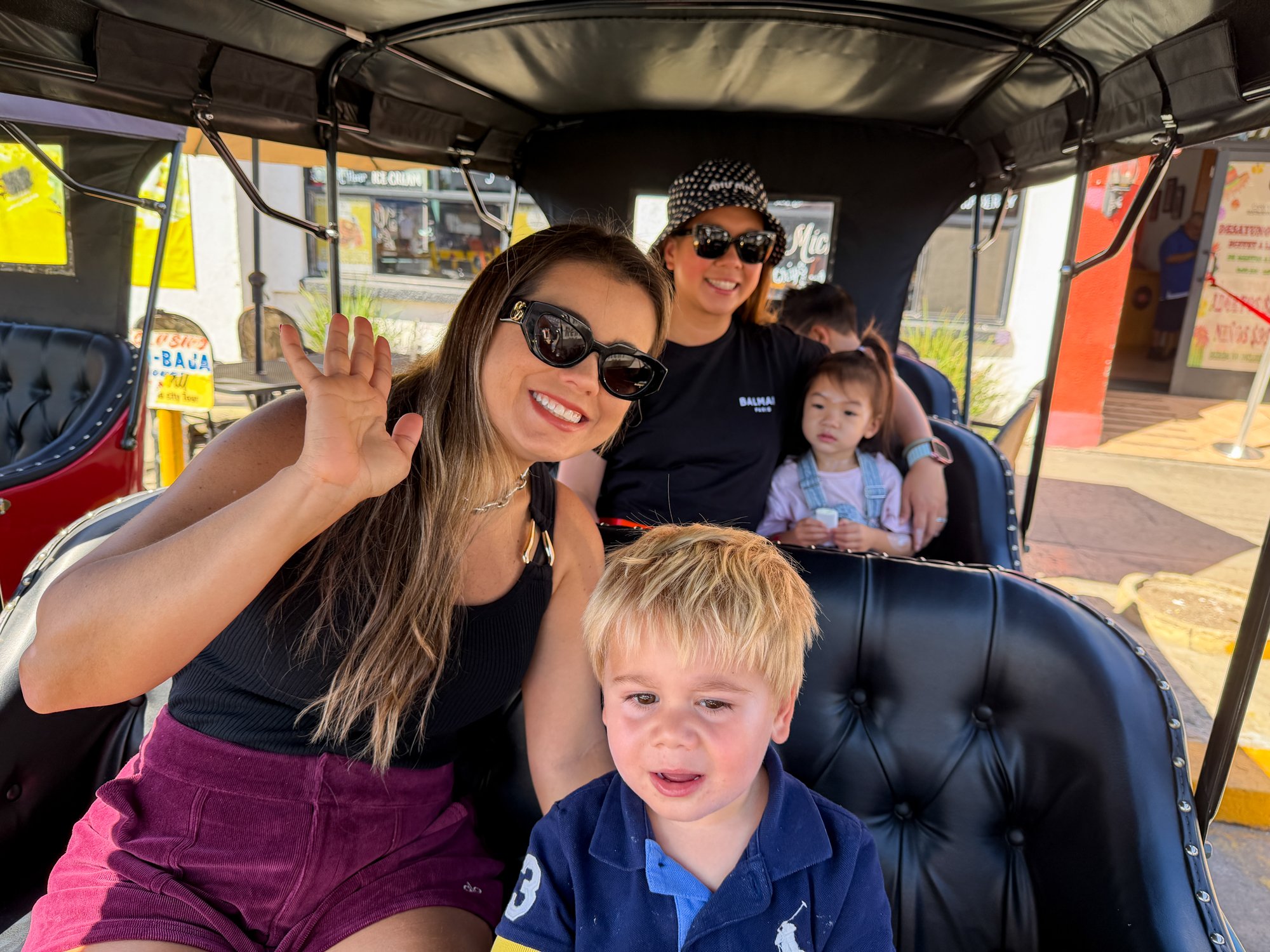 The families riding together in the electric car.