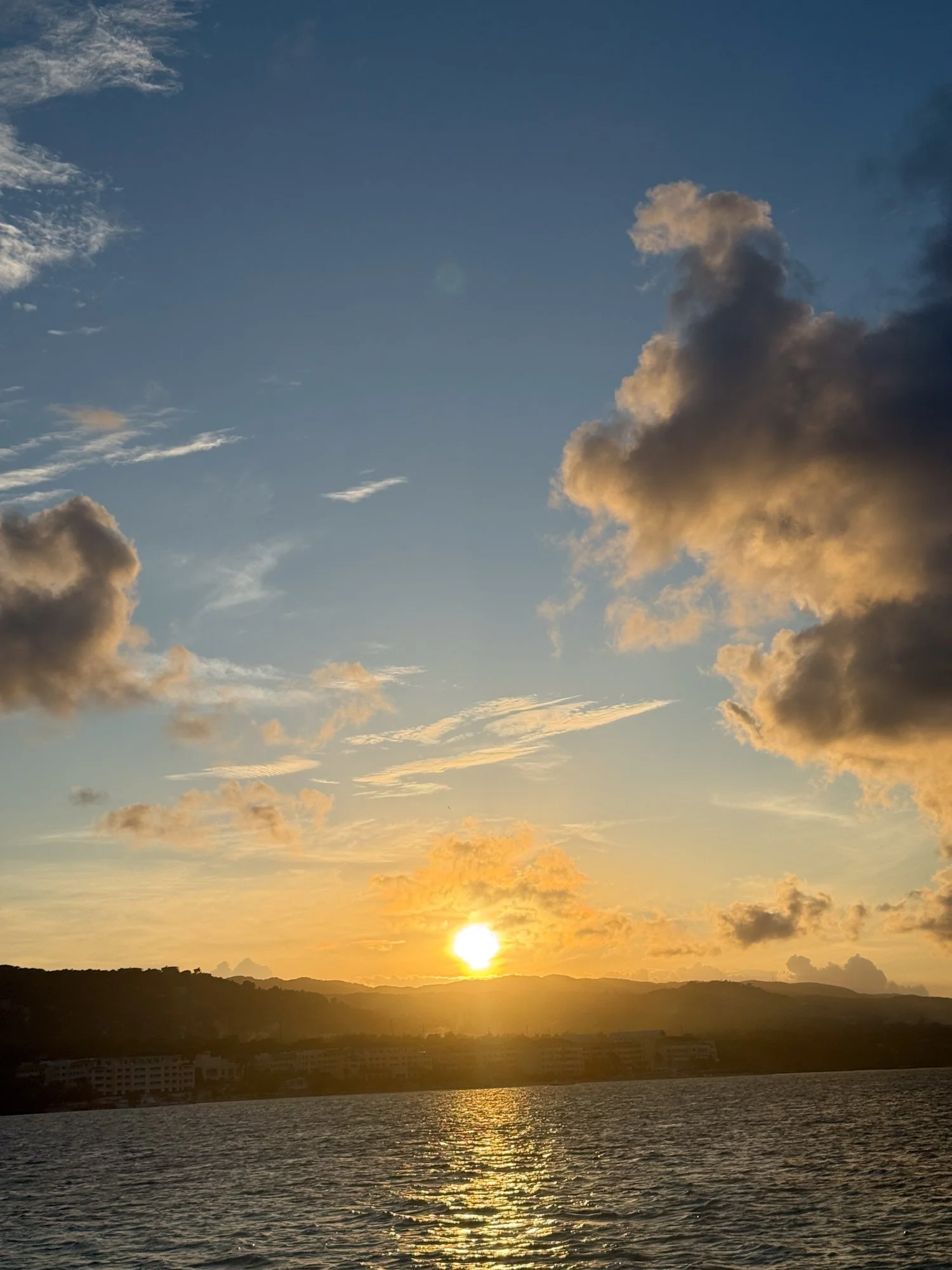 Golden sunset over the sea and rolling hills along Jamaica’s coast.