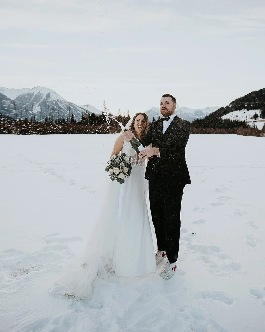 Nothing quite like celebrating in the middle of the mountains. With fresh snow underfoot and the Rockies stretching out behind them, this champagne pop will be remembered forever. Moments like this are what make mountain weddings feel so special.