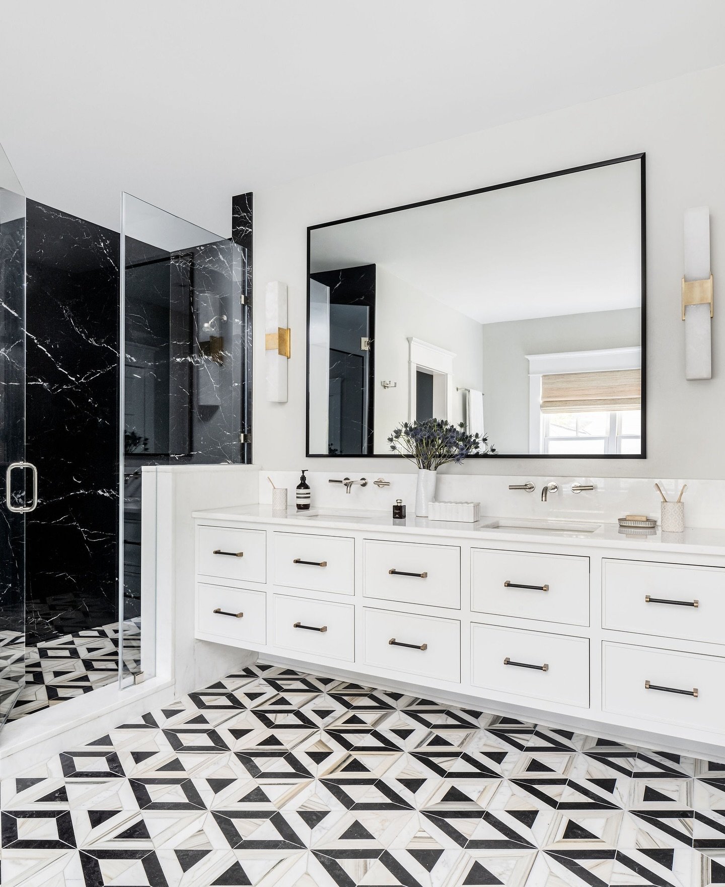 This custom-designed double sink bathroom vanity by @legacycabinetry provides deep drawers and creates the bathroom storage this client could only dream of. We paired it with this black and white @annsacks tile that seamlessly blends traditional and 