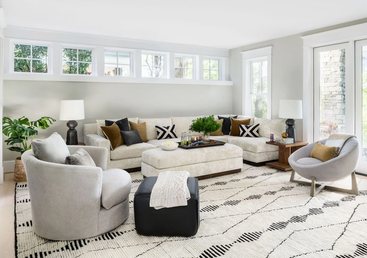 Movie night, anyone? This updated basement entertainment room blends cozy comfort with sleek, modern vibes. Right off the theater space we designed a custom drink-and-popcorn station with @legacycabinetry featuring driftwood-finished drawers and shel