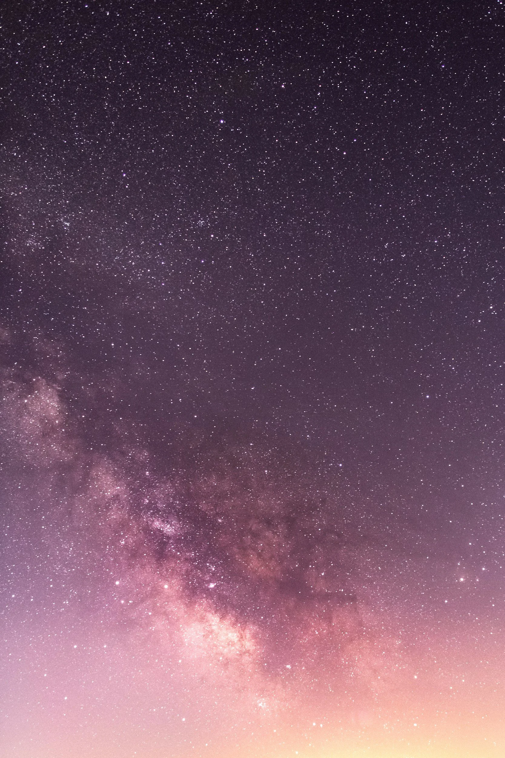 Night sky filled with stars and the Milky Way galaxy visible near the horizon.
