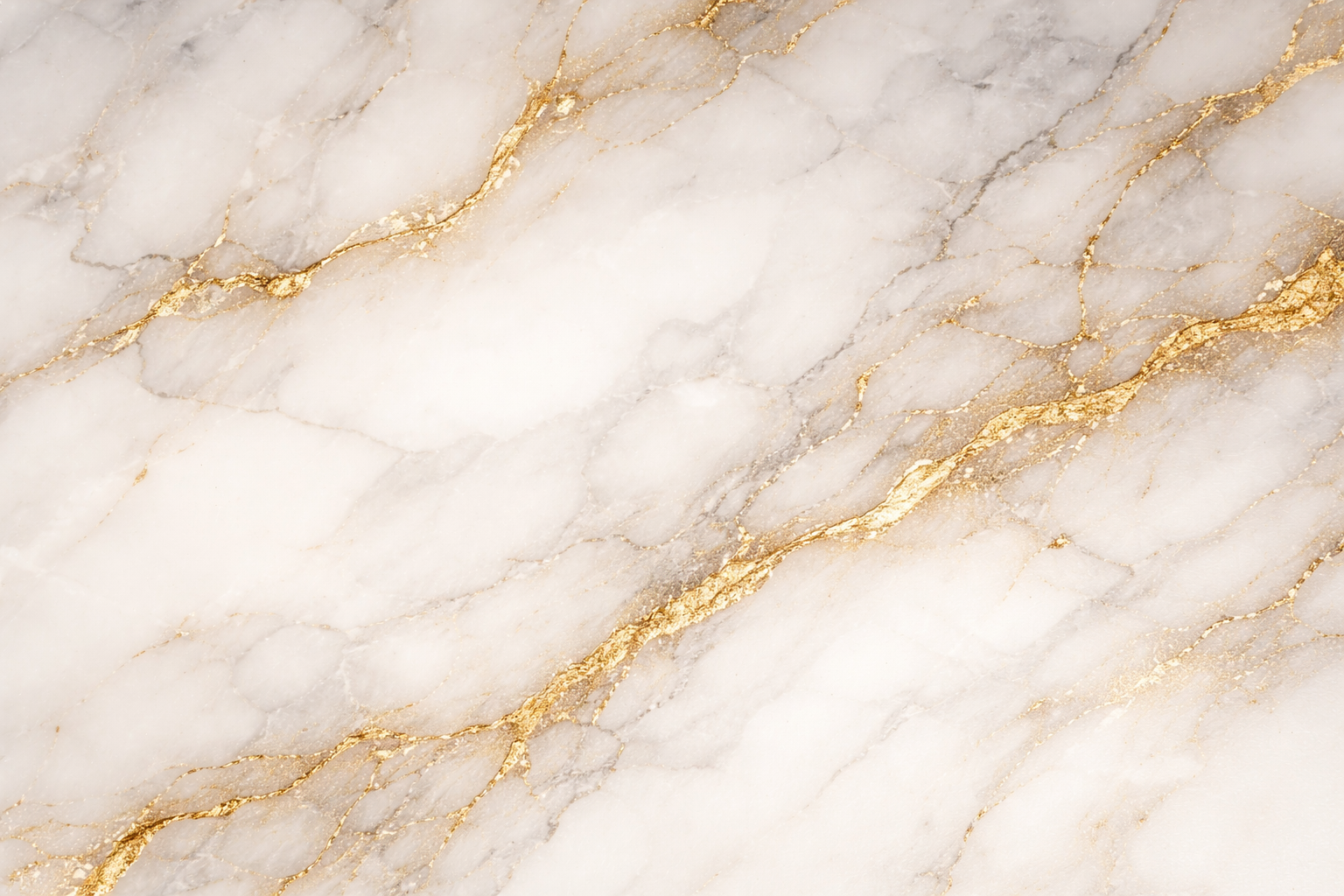 A close-up of a marble surface with a light cream color and gold veining.