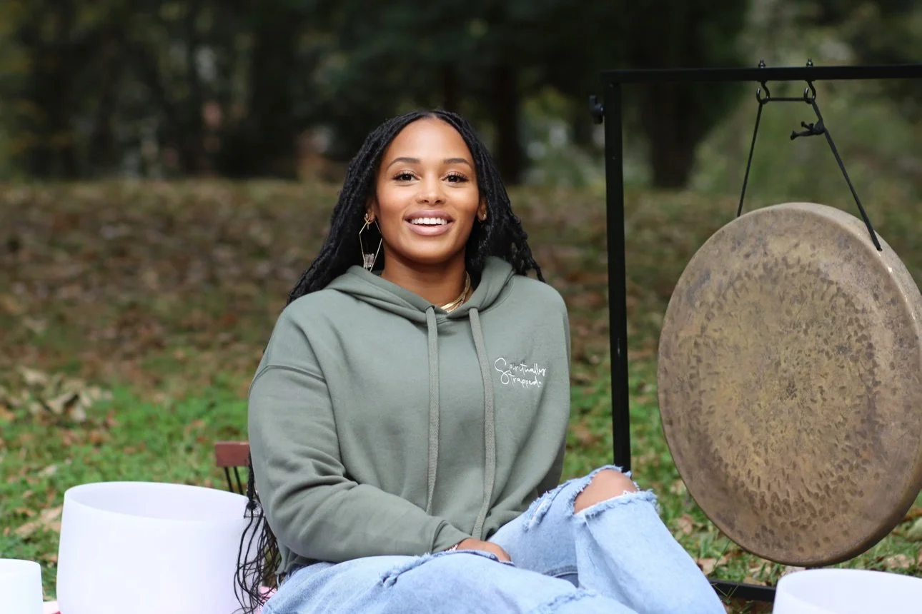 Ashley smiling beside her gong outdoors — her photograph.