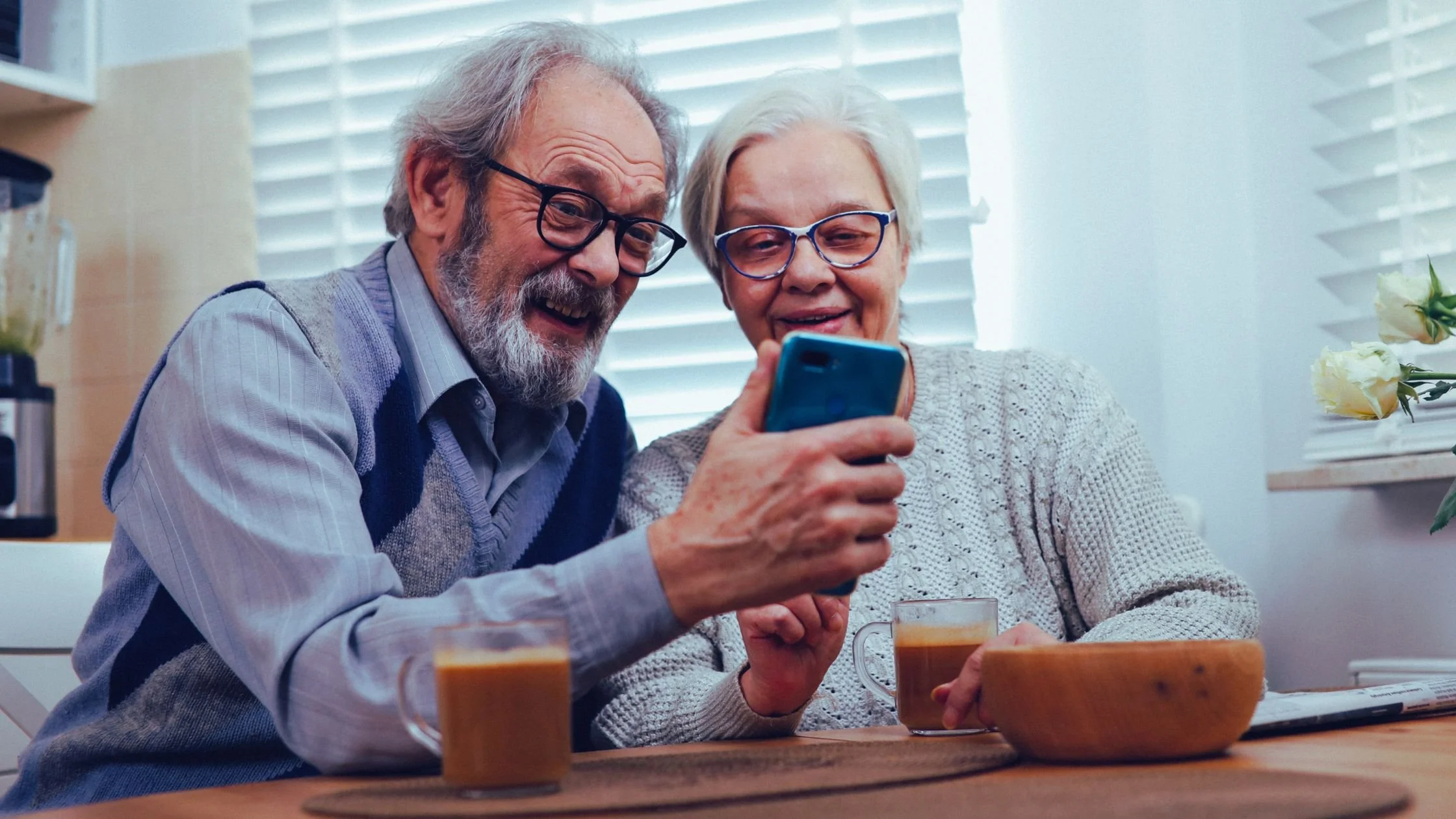 Elderly couple using a smartphone to view healthcare information and access medical services from home.