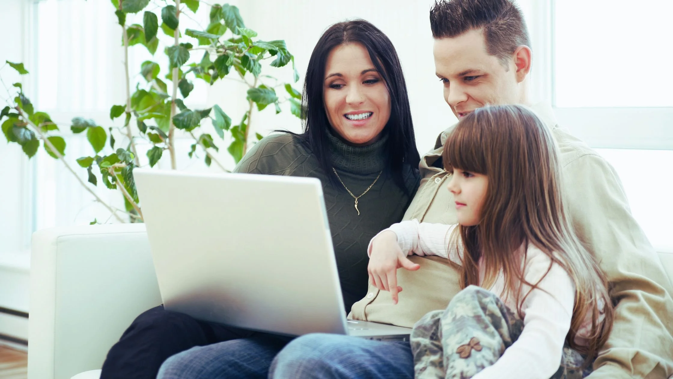 Parents and child using a laptop to view a school’s Facebook and Instagram pages for enrolment information, school activities, and student life.