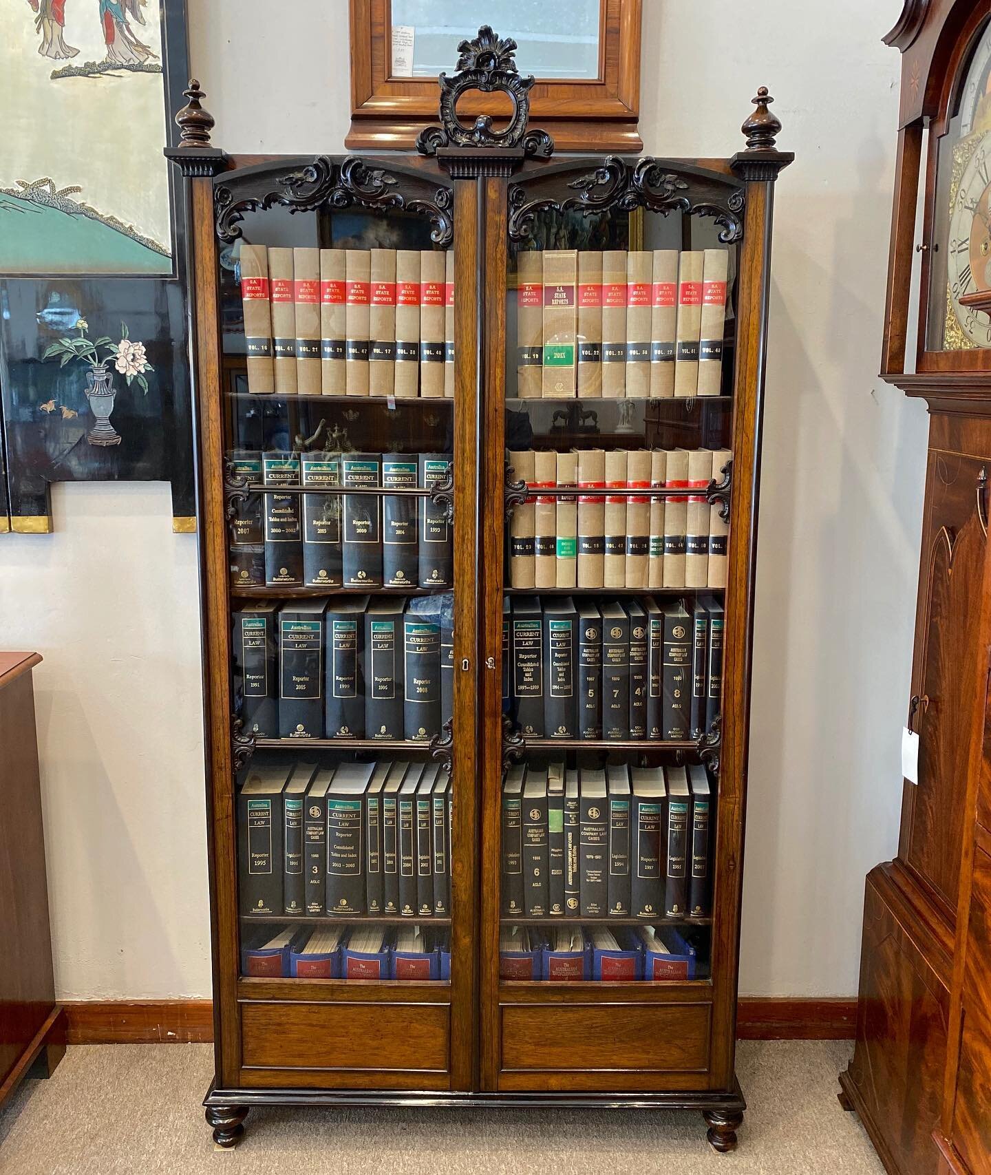 SOLD~ A beautiful 19th century rosewood two door bookcase, wonderfully carved doors and pediment, turned feet, has it&rsquo;s original glass and adjustable shelving. Interior grained in faux rosewood.