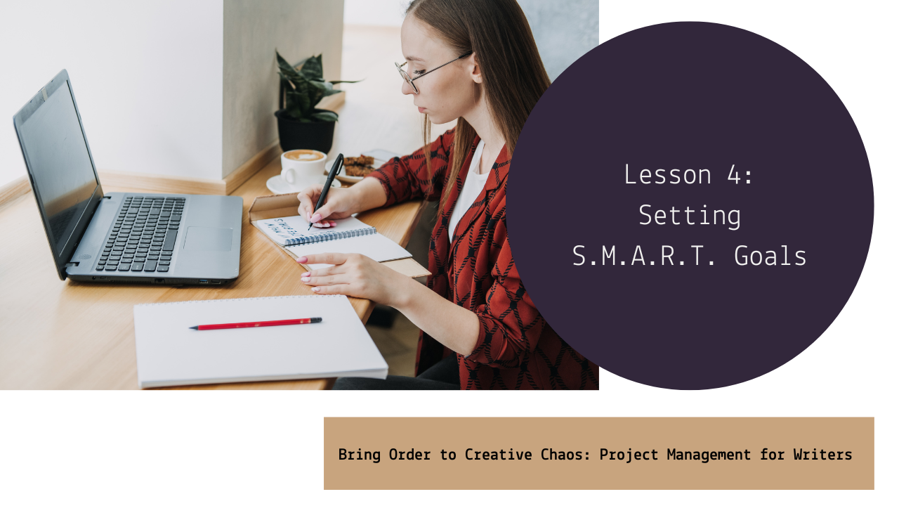 A woman with glasses and long hair, wearing a red and black patterned shirt, is sitting at a wooden desk writing in a spiral notebook with a pen. On the desk are a laptop, a red pen, a white notebook, a cup of coffee, and a plant. The workspace is neat and well-lit.