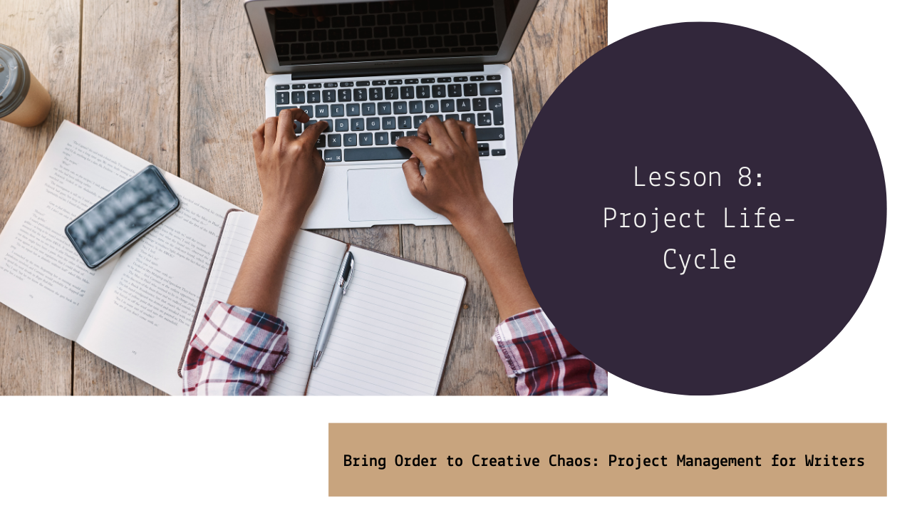 A person working on a laptop at a wooden desk with an open notebook, a smartphone, a pen, and a takeaway coffee cup nearby.