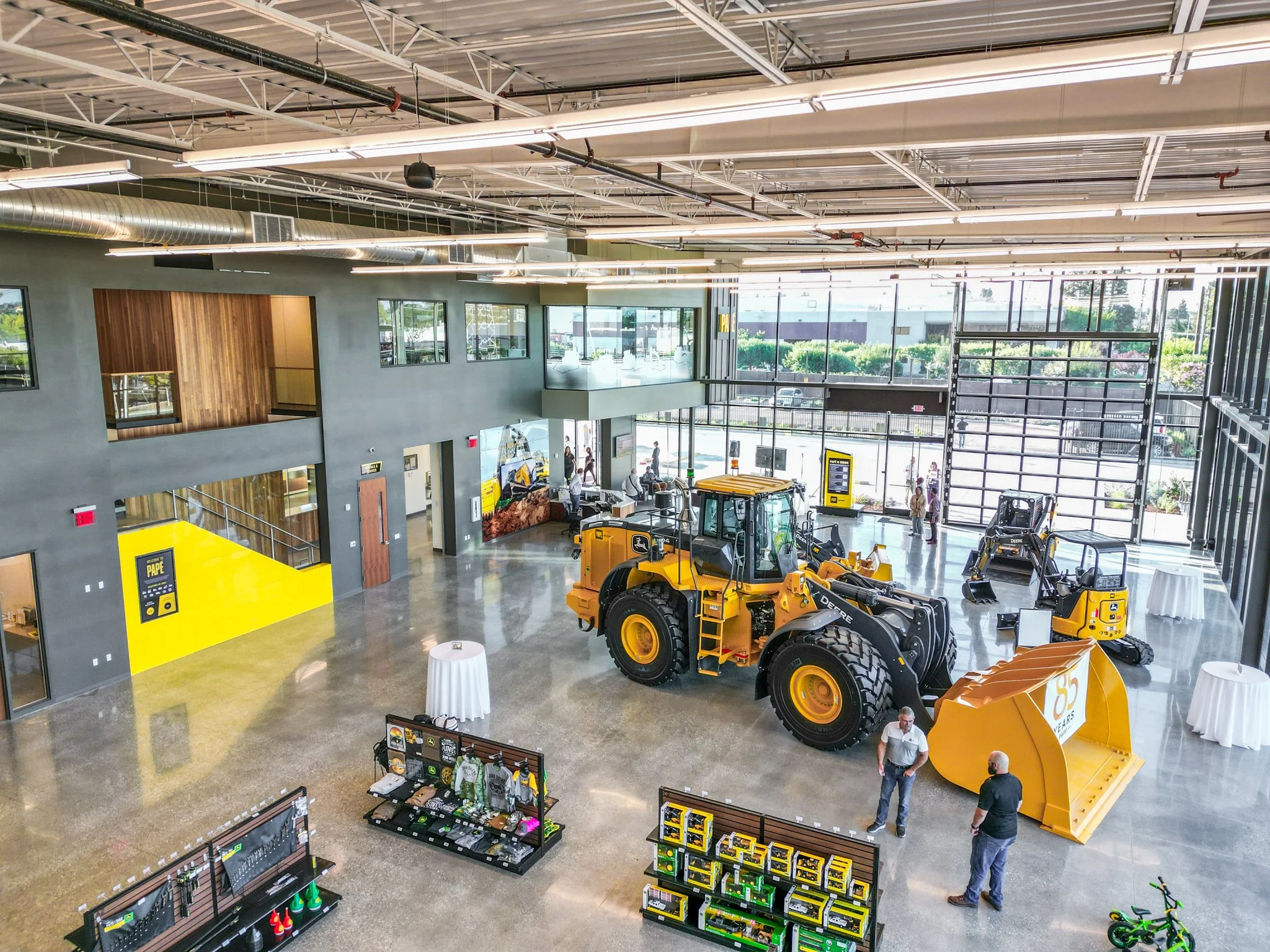 The yellow wall of the stairway is clad in second surface client branded color acrylic wall with a 60" portrait inset mounted touchscreen with a custom created app of corporate information and marketing. The elevator shaft is clad in vertical slats o