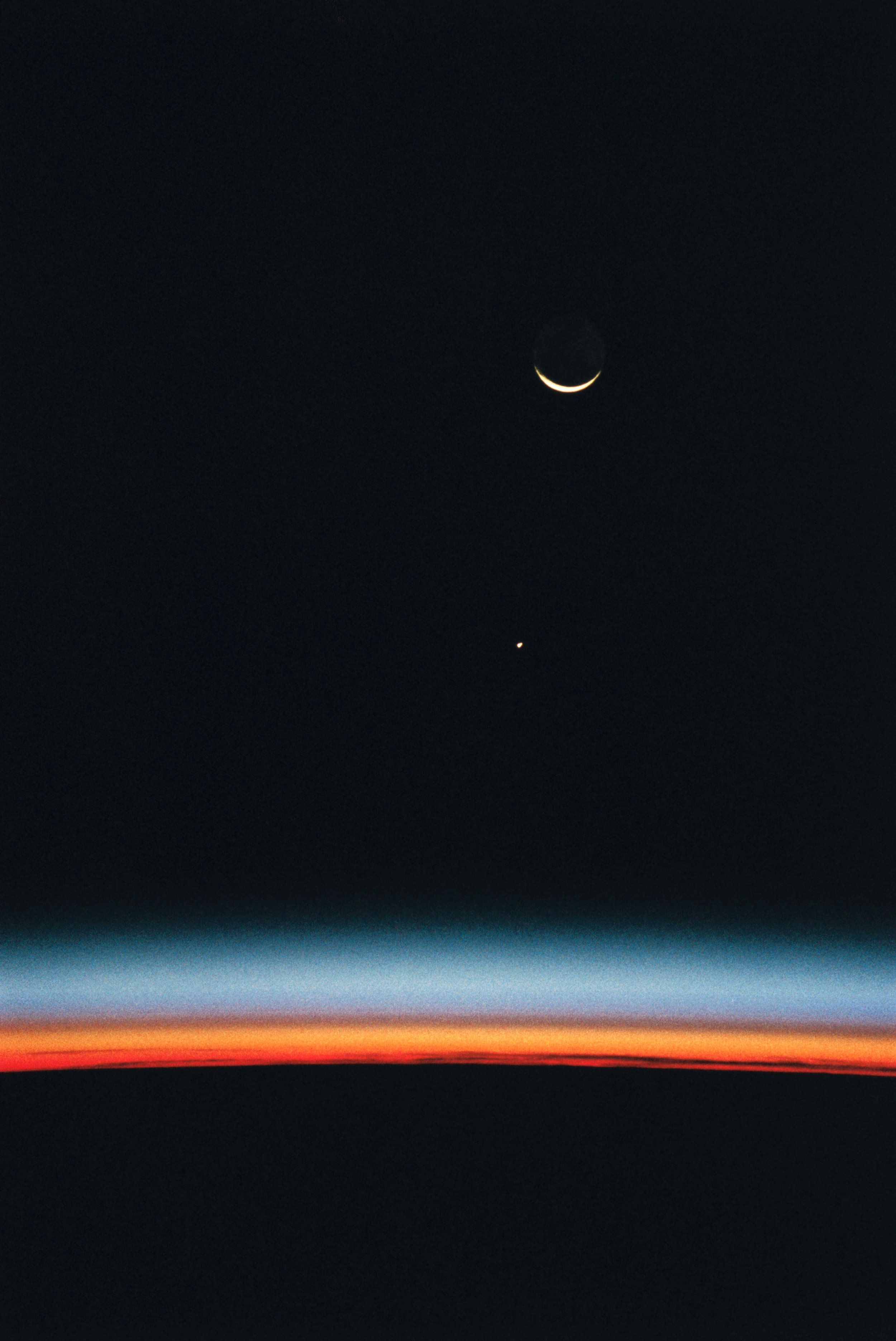 Hubble_Space_Telescope_with_an_Airglow_over_Earth's_Horizon,_Jupiter,_and_a_Crescent_Moon_(27514173904).jpg