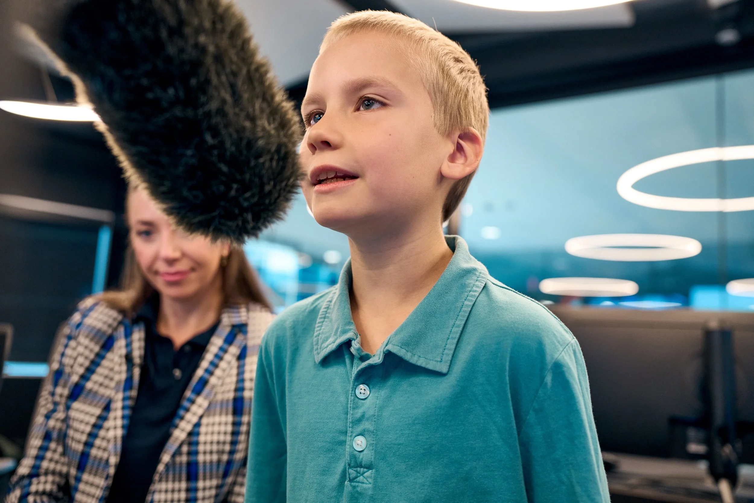 A young boy asks a question into a mic. The Ax-2 astronauts took questions from children of Axiom Space employees during the HERA mission.
