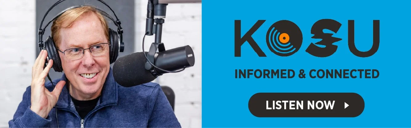 A man with red hair and glasses speaking into a radio microphone with headphones on in a recording studio. A promotional graphic for KOSU radio features the station's logo, the words 'Informed & Connected,' and a 'Listen Now' button.