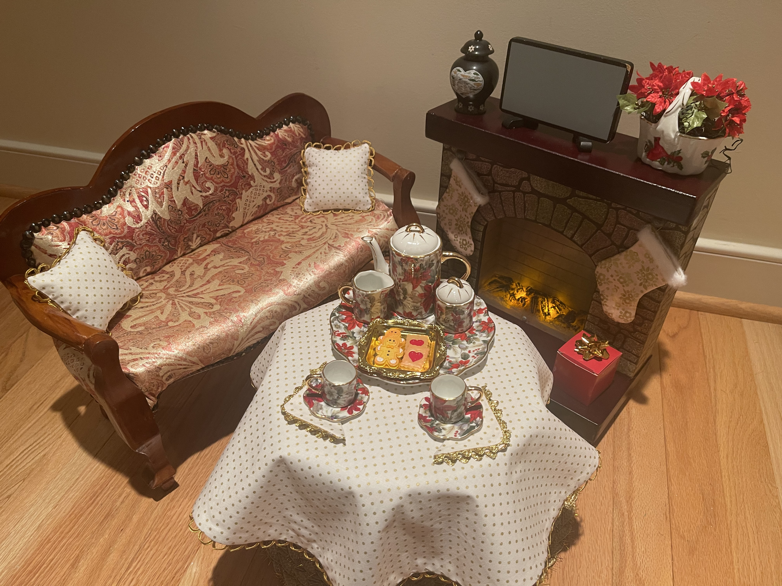 This living room set includes an up-cycled sofa, fireplace with battery-powered fireplace, some decor, and removable Christmas stocking. The coffee table features a holiday china tea set and some cookies. Coffee table is a nice pedestal wood table. $