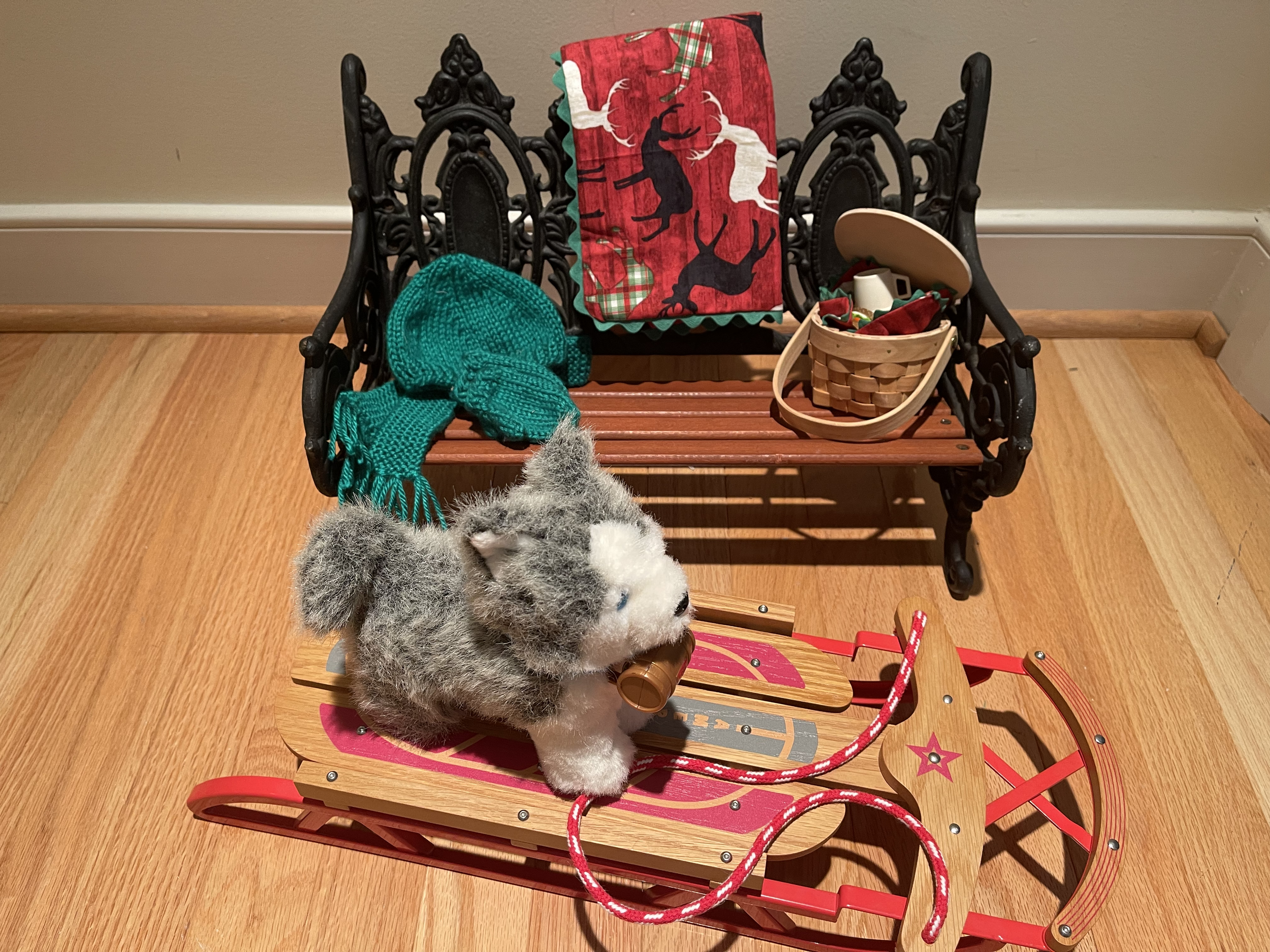 Wood and metal bench features hand-knitted hat, gloves, and scarf; afghan; lunch. Also included are up-cycled American Girl doll and sled. $84.