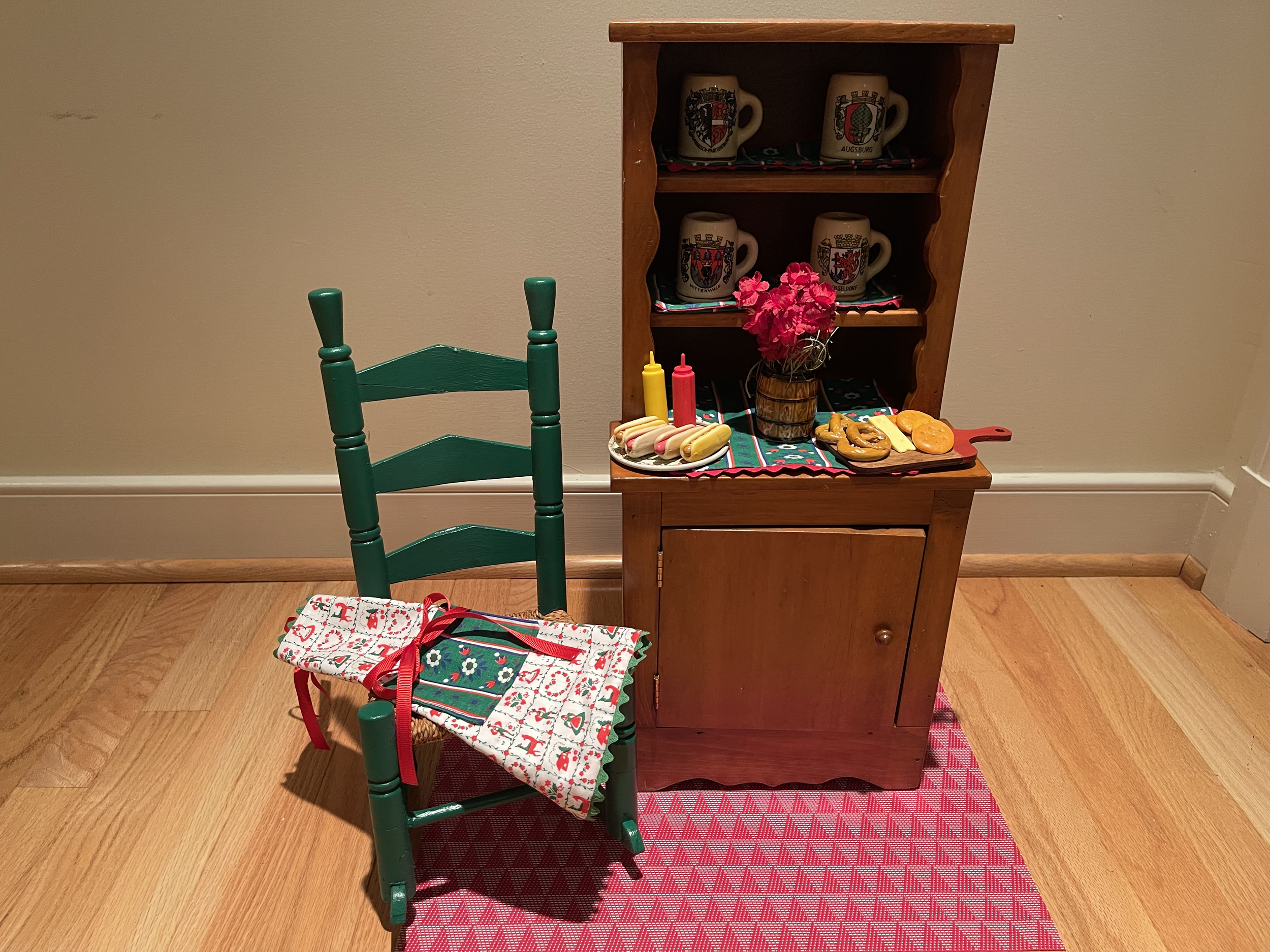 Vintage cupboard with German mugs, food, chair, and apron. $72