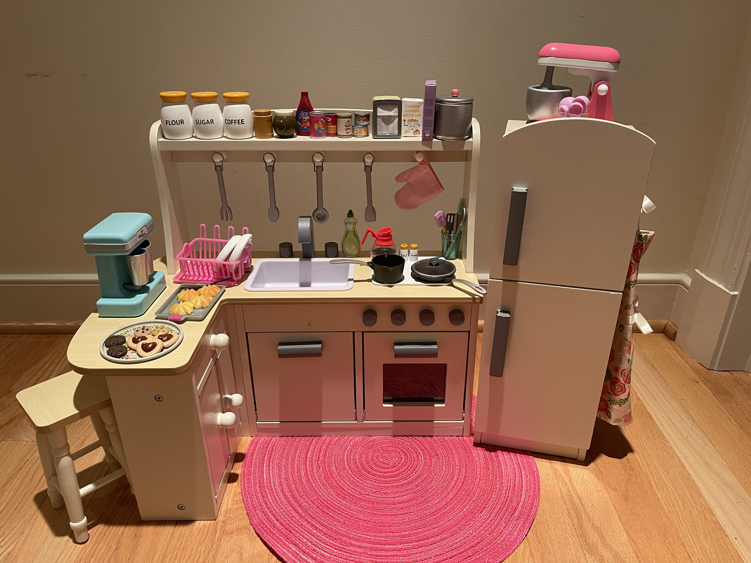 This kitchen features everything needed for cooking fun! there are dishes and utensils in the cabinets and the refrigerator and freezer are full of food. An apron is also included. $82