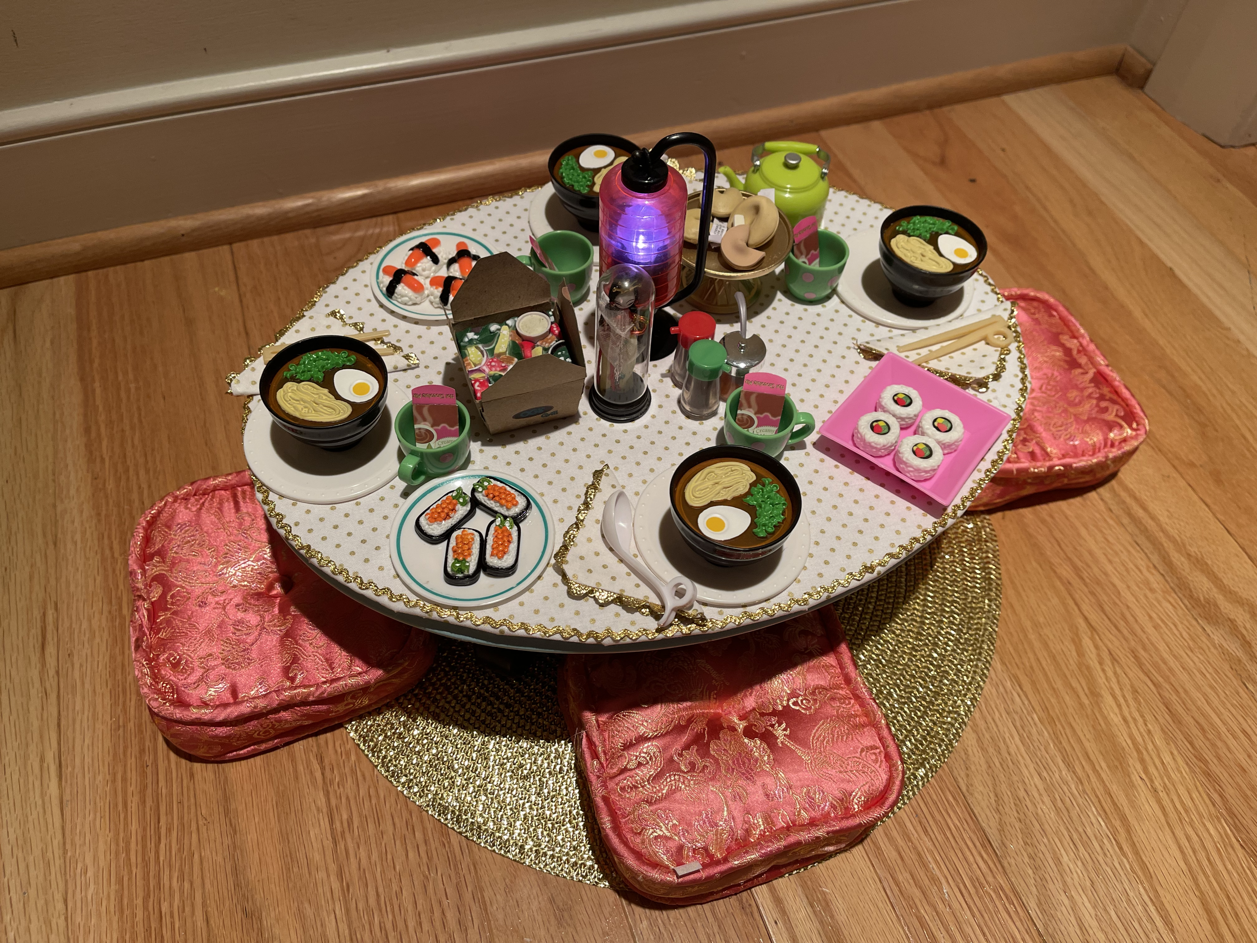This Asian meal features an up cycled American Girl table and seating cushions. Included are lots of food items, a lighted centerpiece, and an Asian doll under glass. $124