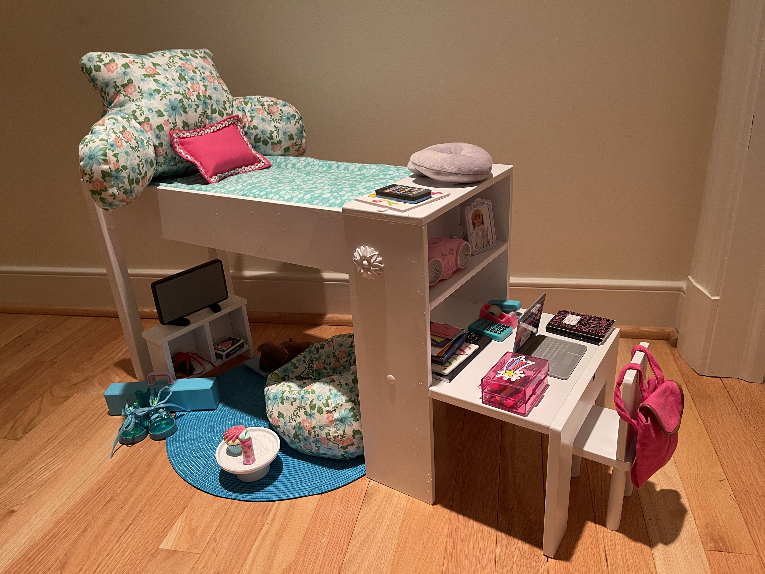 Loft bed features all bedding and custom lounge pillow. Included are a desk complete with supplies and a backpack.  There is a bean bag chair and snack table for the tv-watching, music-listening area. Included also are a dog and his bed. $132