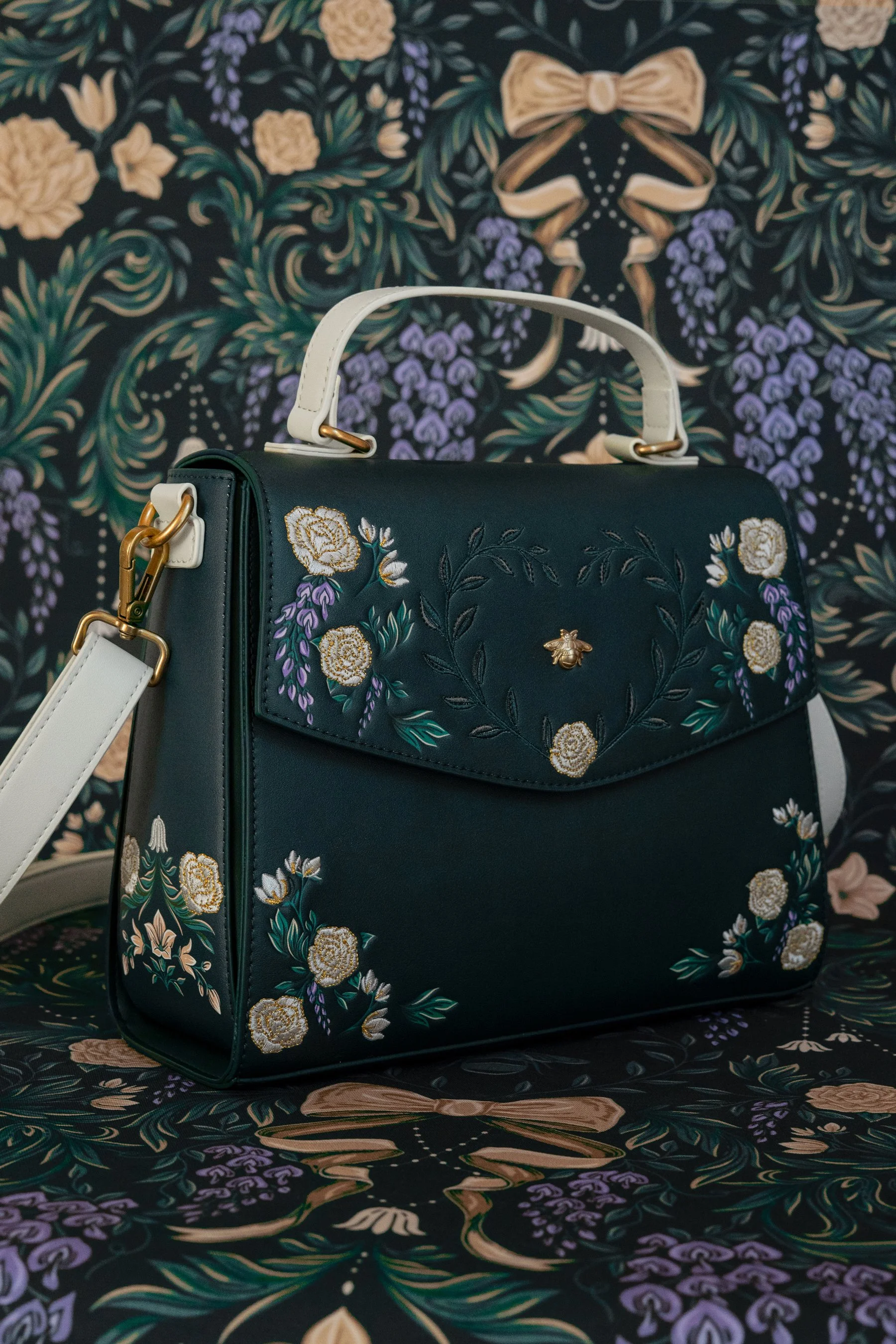 Pattern illustration by Maggie Enterrios for Bridgerton Loungefly limited edition collection. Image of green embroidered purse on intricate illustrated damask floral background