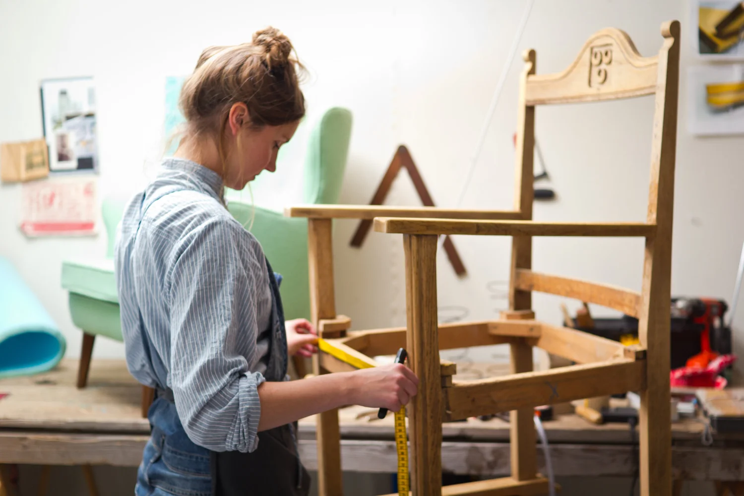 Stoffeerder meet een stoelframe op in het atelier in Vlaardingen