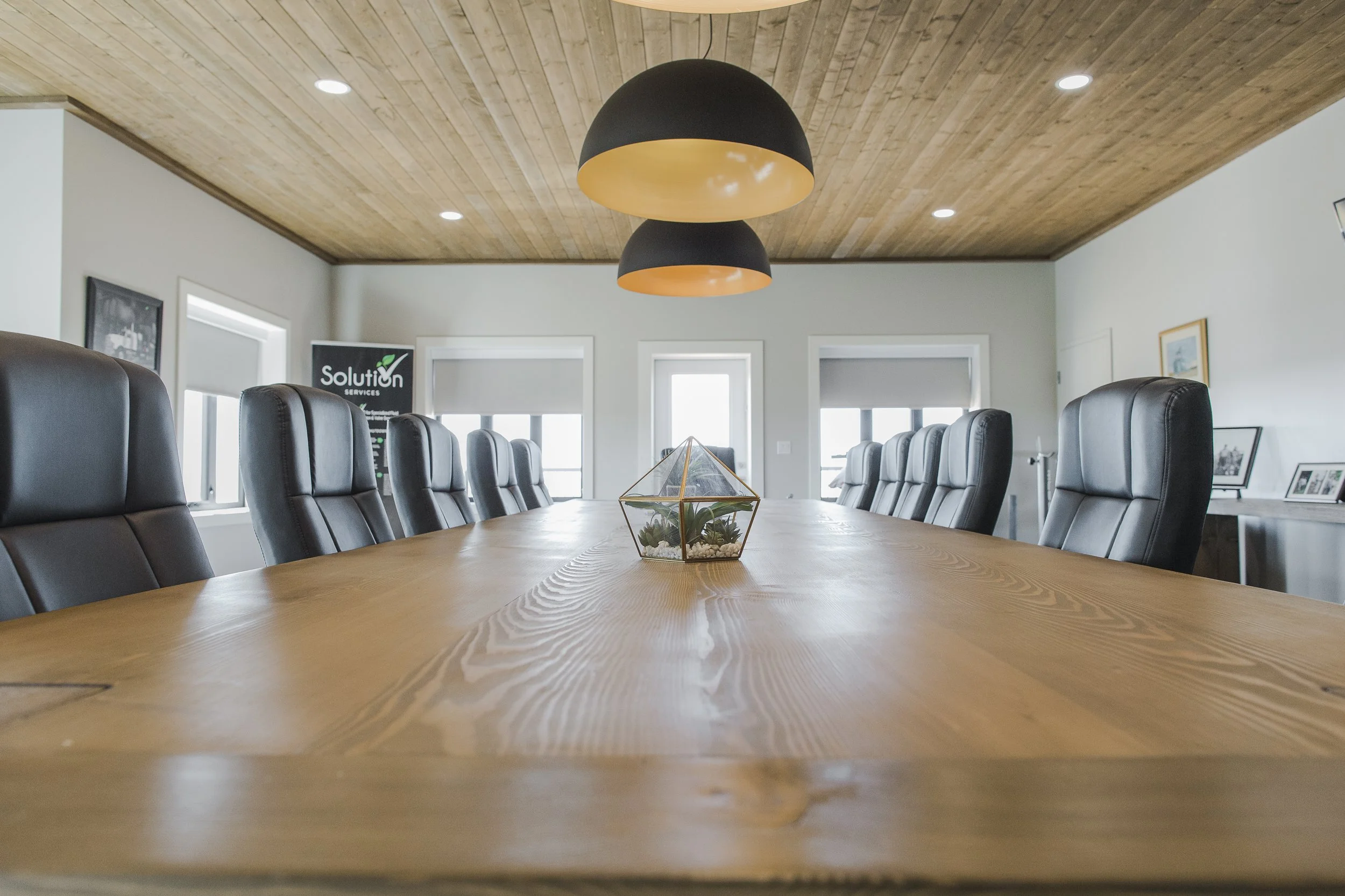 Luxury corporate boardroom with custom wood ceilings and custom built Timberframe boardroom table at a Commercial Project by Blackrock Homes & Commercial in Grande Prairie, Alberta