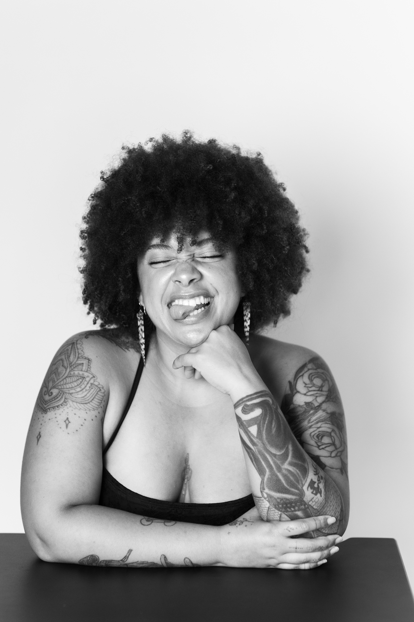 Playful black and white portrait of a woman seated in a studio portrait session in San Luis Obispo County.