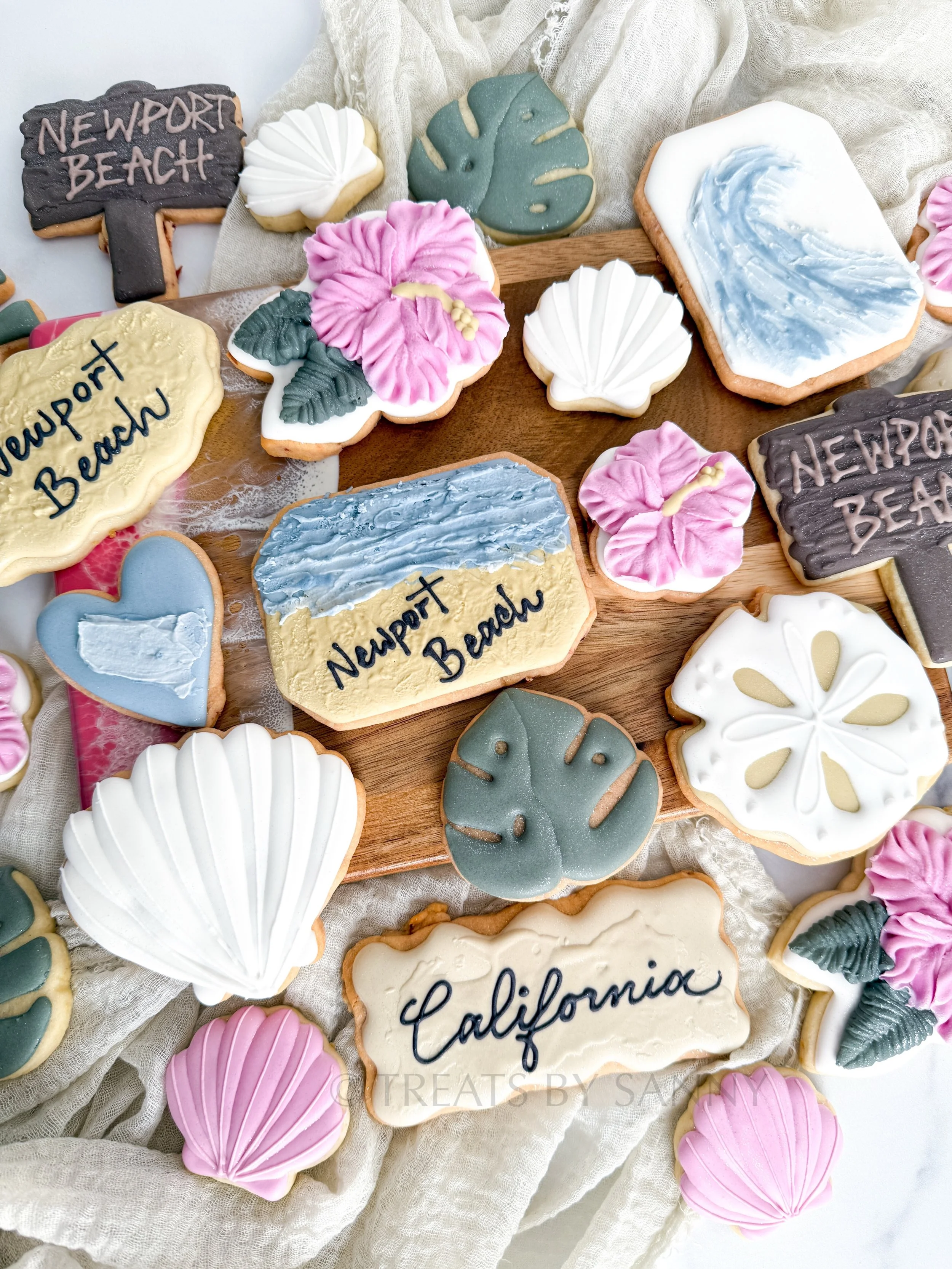 Traveling cookies - Newport Beach edition! 🌊☀️ Coastal vibes, sandy beaches, and nicer weather in Southern California 😎  Swipe to see some cookies hanging out by the ocean! 

All cookies decorated with natural food coloring from @thesugarart 

cook