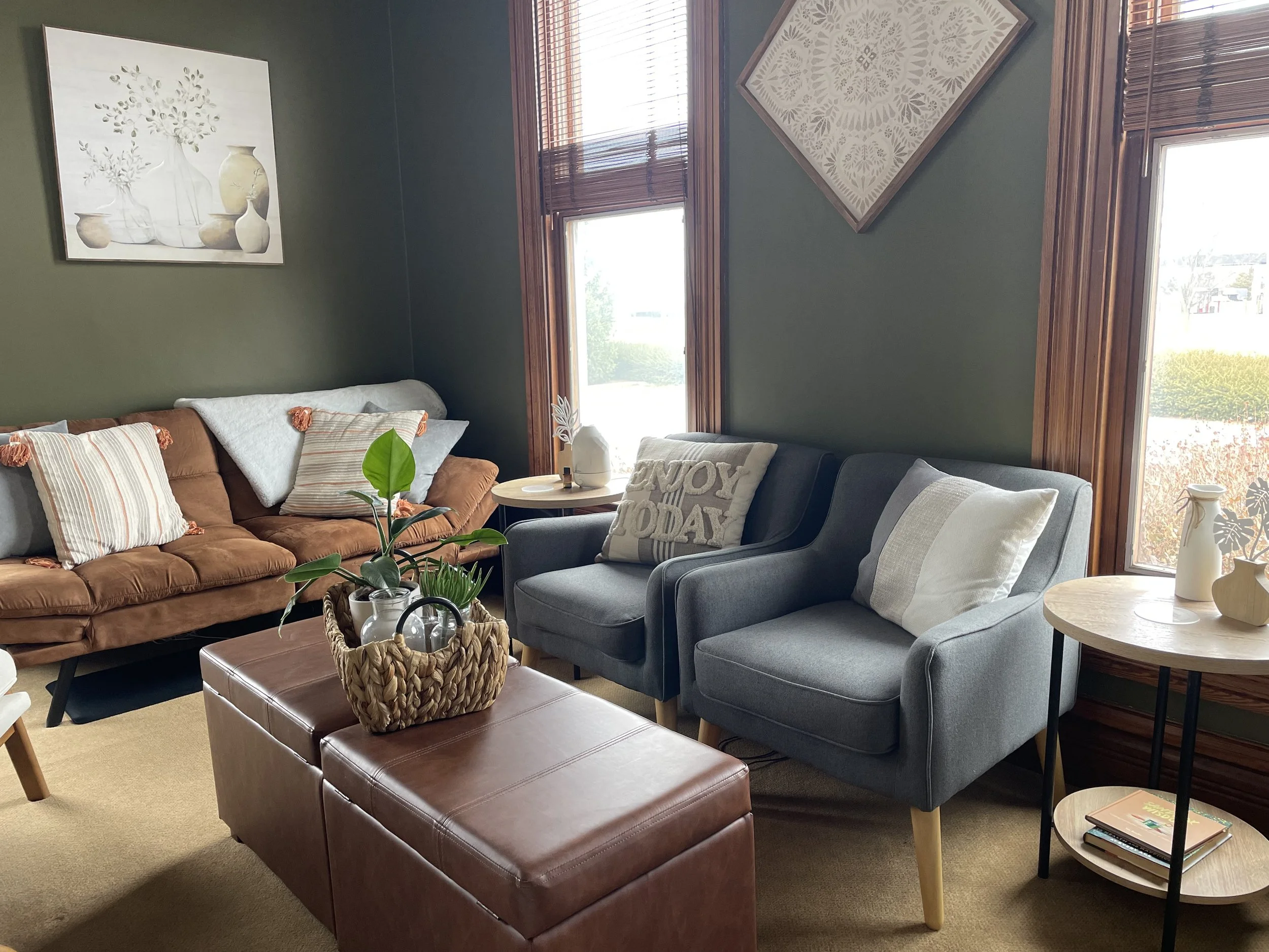 a comfortable inviting green office with 2 chairs and a couch nicely decorated