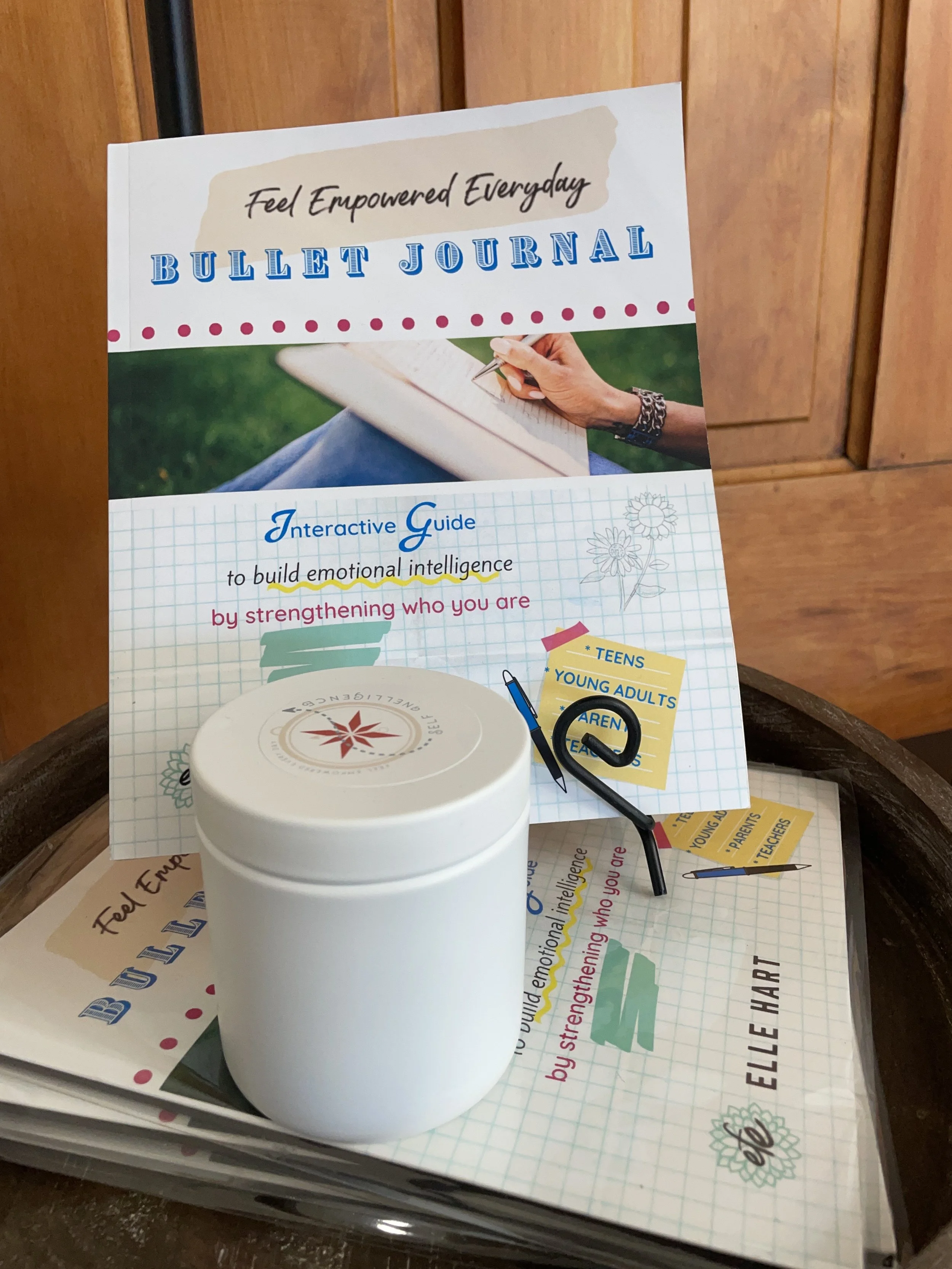 the feel empowered every day bullet journal book on a stand with a candle
