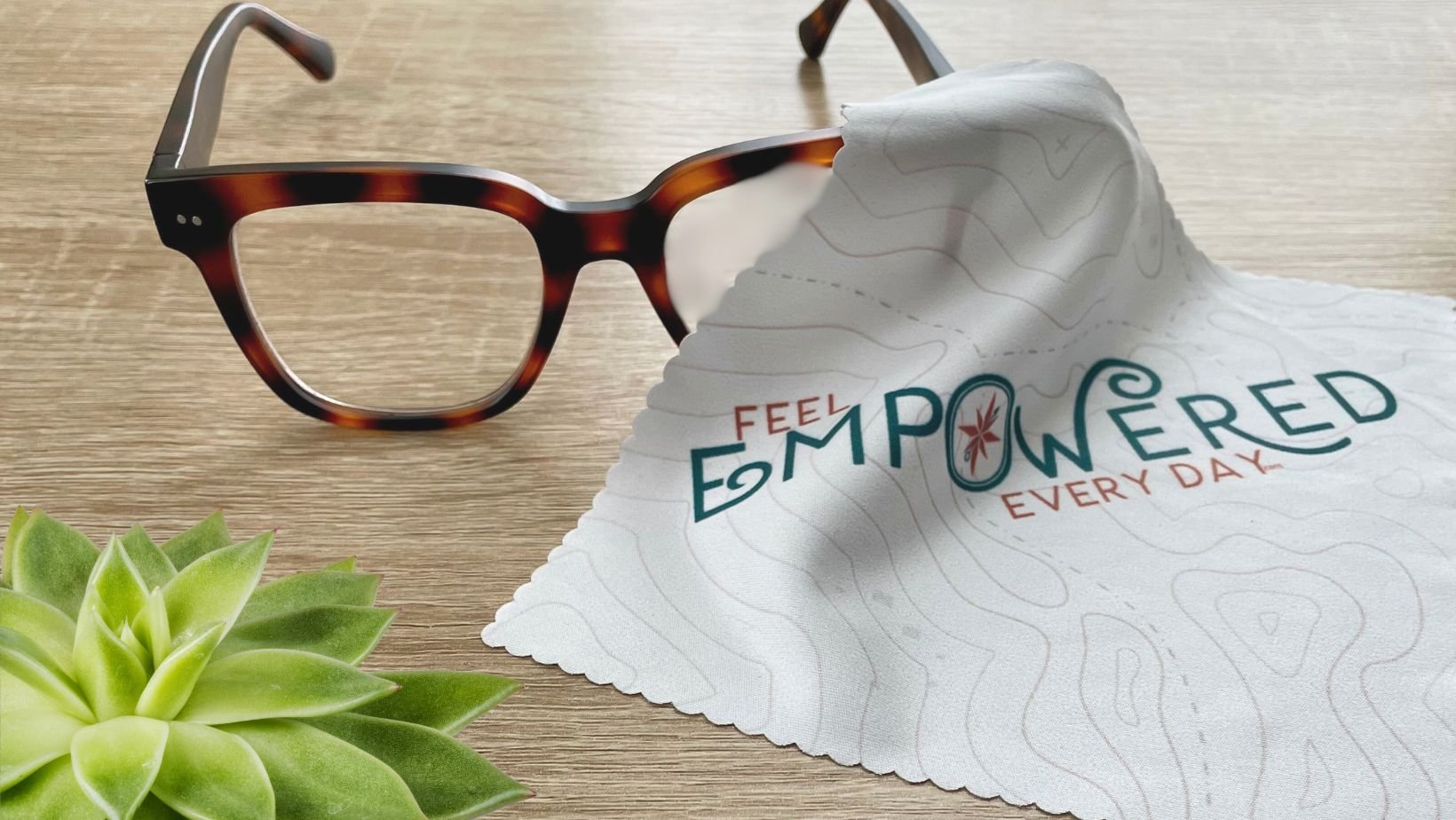 a pair of glasses with a feel empowered every day branded lens cloth