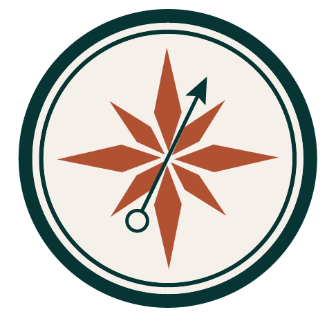 A compass rose with a brown eight-point star and a needle pointing northeast, encased in a circular border.