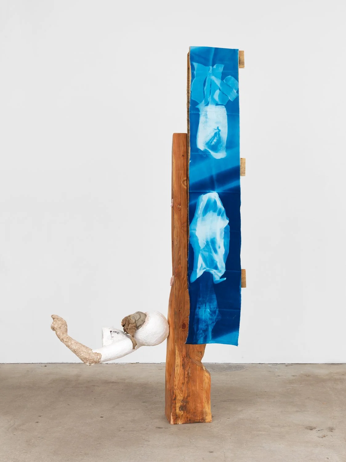  Cato Ouyang   carrier / the seeking soul , 2026, wood, cyanotype on cotton, plaster, extruded polystyrene, steel, soapstone, found textile, 75 x 41 x 17 inches, 190.5 x 104.1 x 43.2 cm.