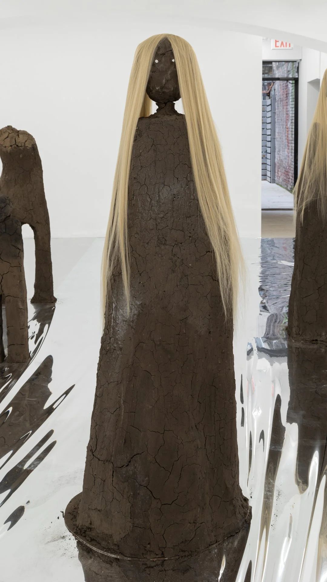 Kiyan Williams,  Sentient Ruin 7 , 2022, earth, binder, chrome, synthetic hair, steel base and armature, 72 x 27 x 30 inches, 182.9 x 68.6 x 76.2 cm 