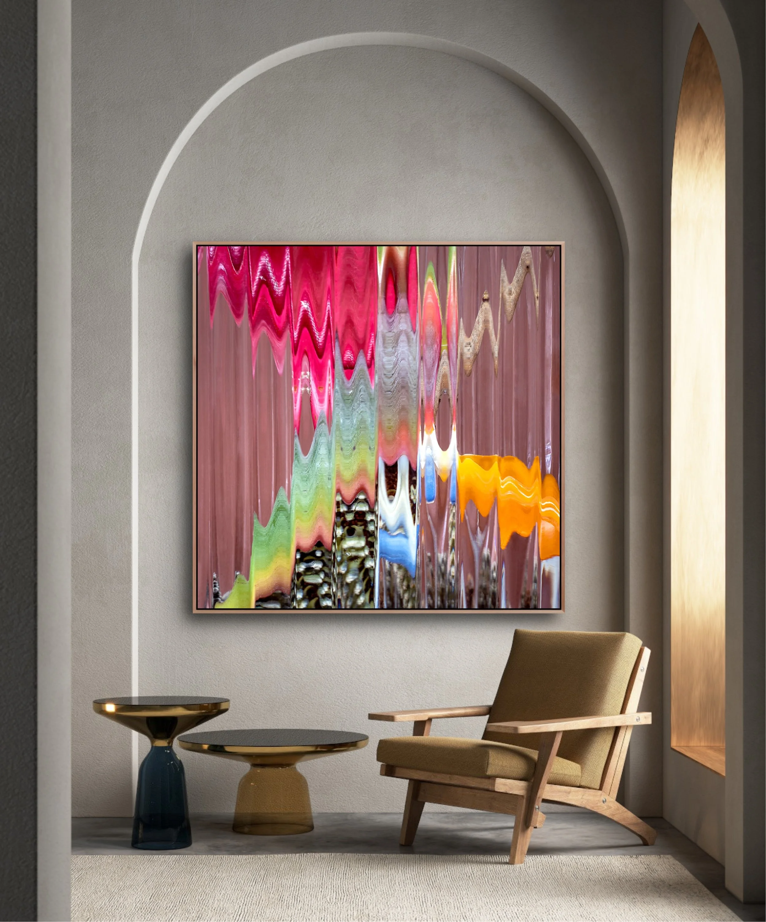 Interior living space with a modern beige armchair, two glass side tables, and a colorful abstract painting on the wall.